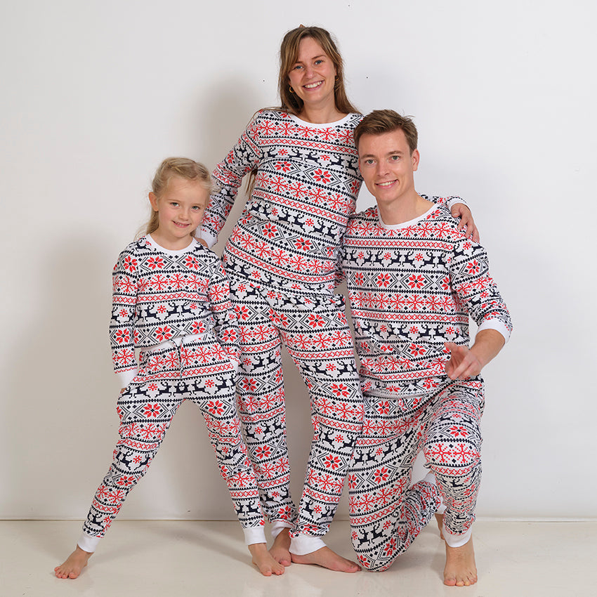 En dame, en mand og et barn iført et sæt julepyjamas med mønster.