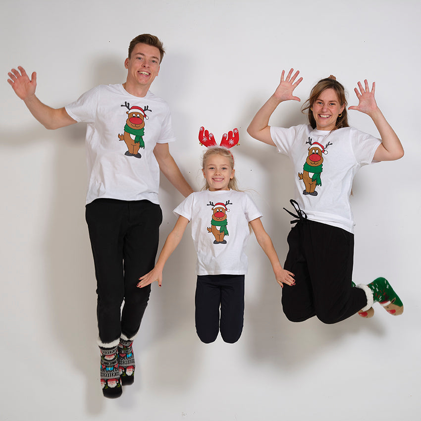 En hoppende mand, dame og et barn iført hvide jule-T-shirts.