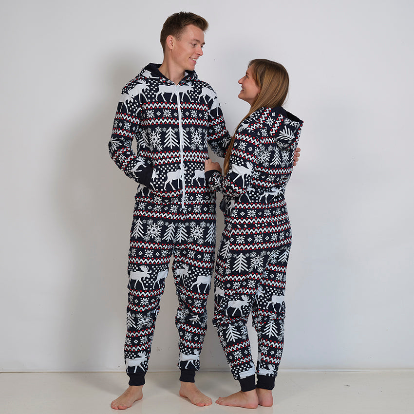 En mand og en dame står samme i hvert deres julejumpsuit.