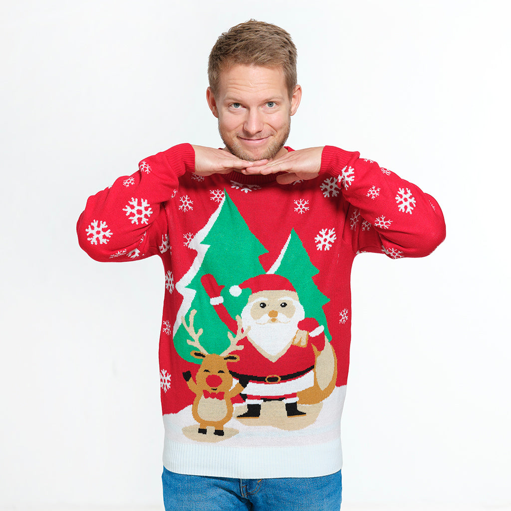En mand poserer med hænderne op til sit ansigt iført en rød julesweater.