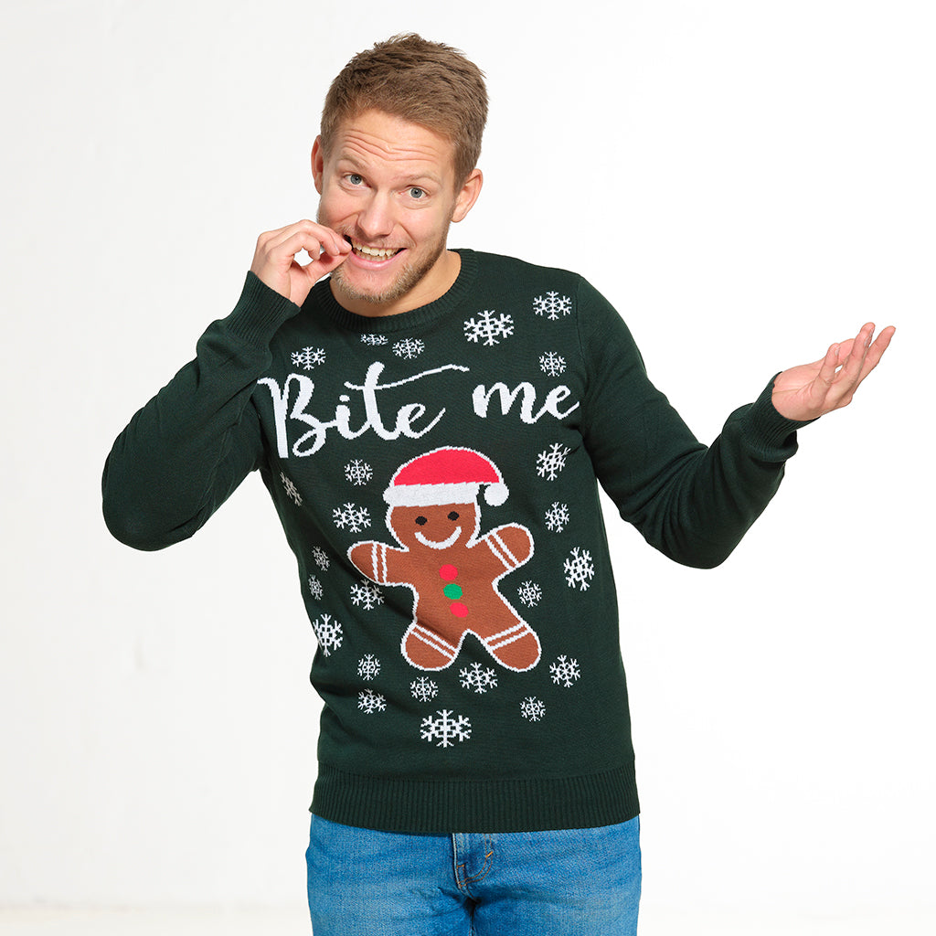 En mand, som er iført en grøn julesweater, der bider i noget.