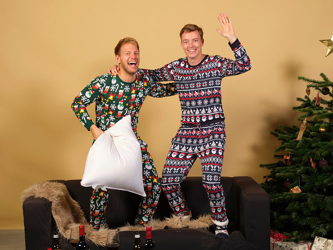 To mænd poserer sammen i hver deres sæt julepyjamas.