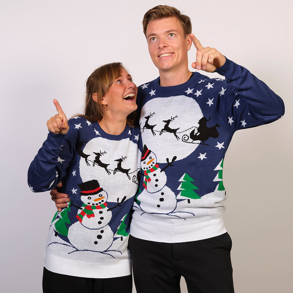 En mand og en kvinde poserer sammen i hver deres julesweater.