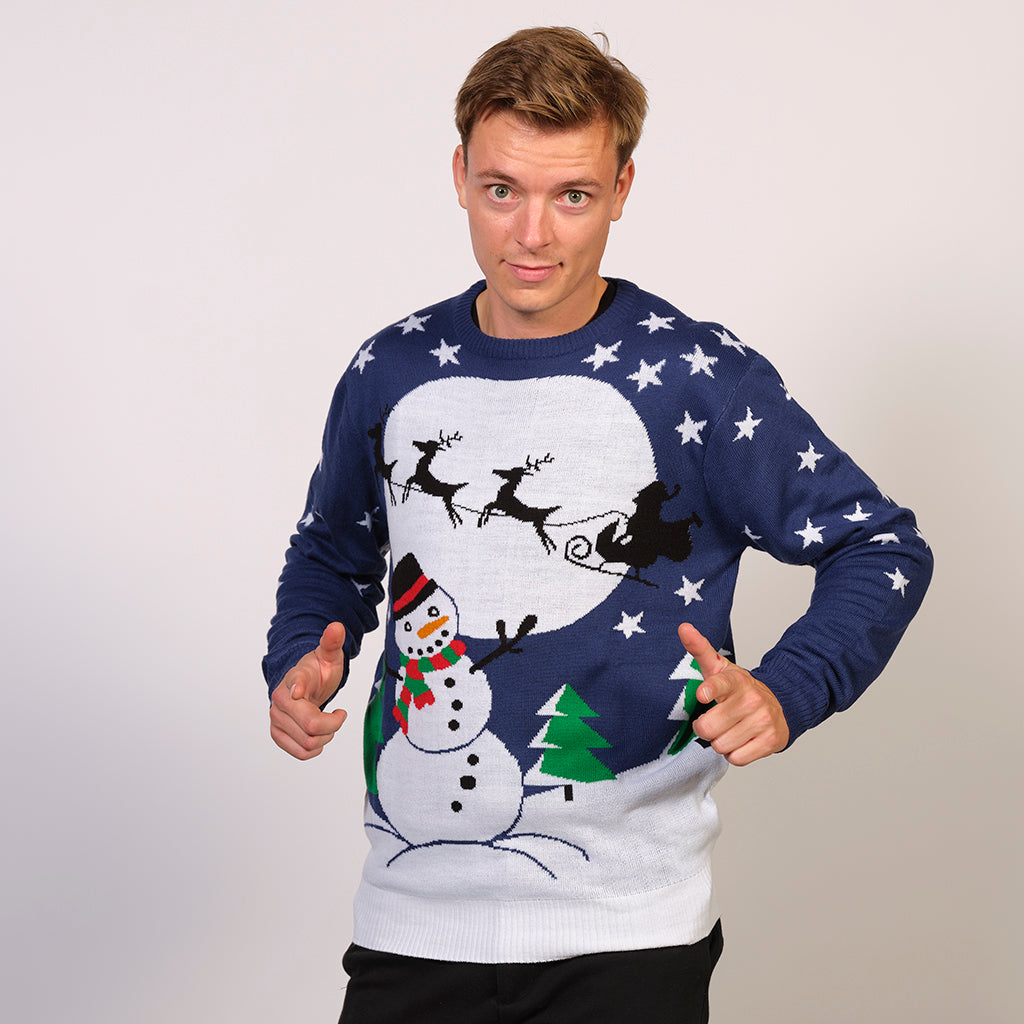 En mand iført en julesweater med et snelandskab på.