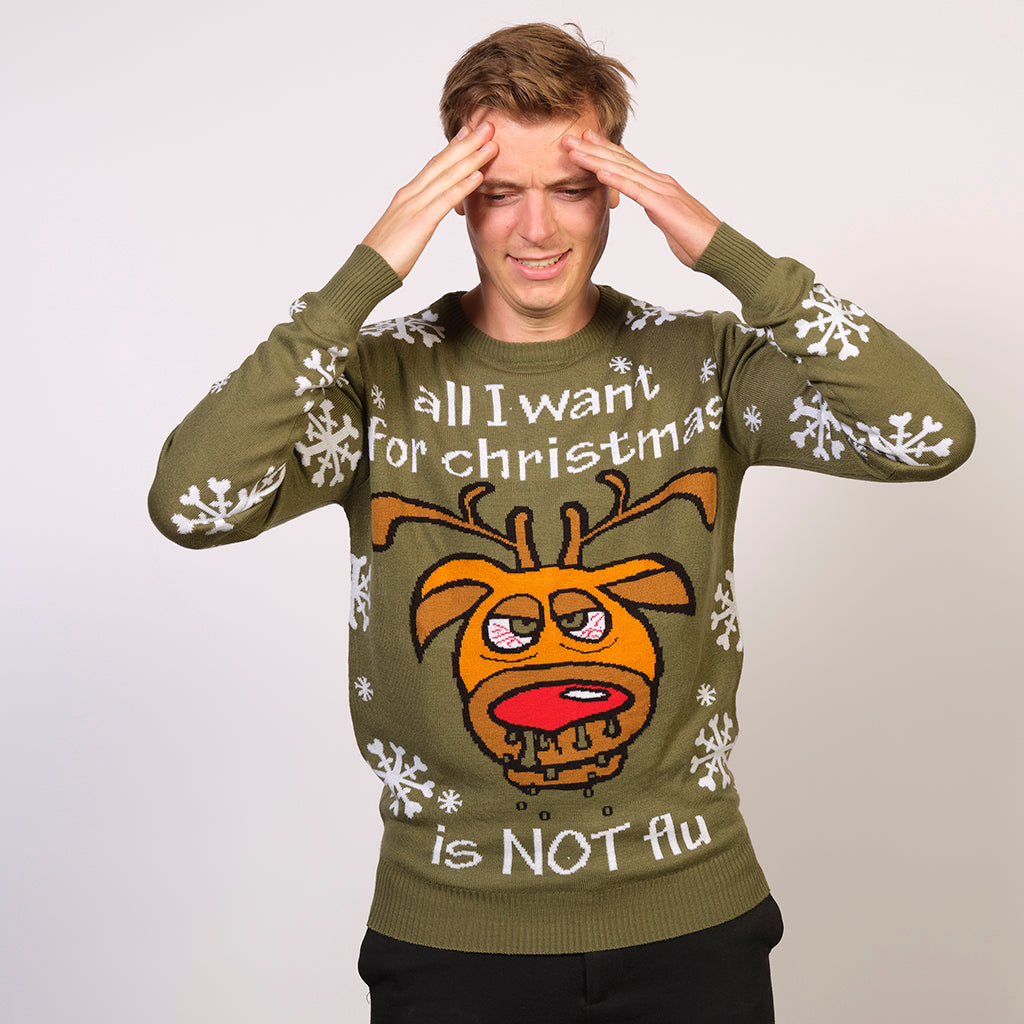 En mand der tager sig til hovedet er iført en grå-grøn julesweater.