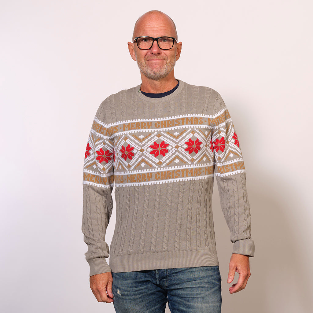 En mand i en grå julesweater med mønster på.