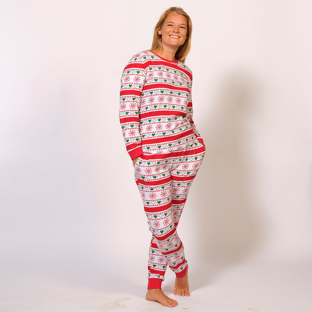 En smilende kvinde iført et par hvide julepyjamas.