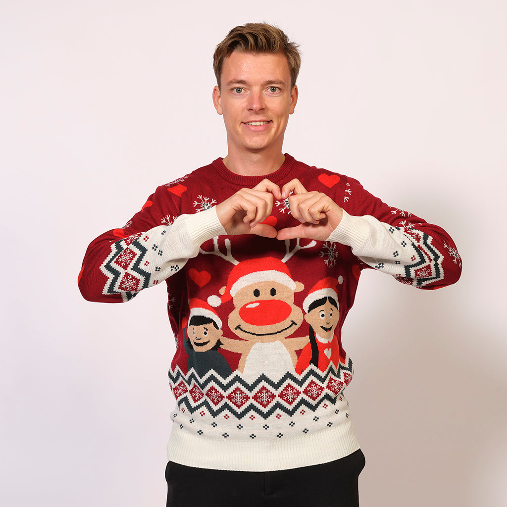 En mand poserer i en rød julesweater.
