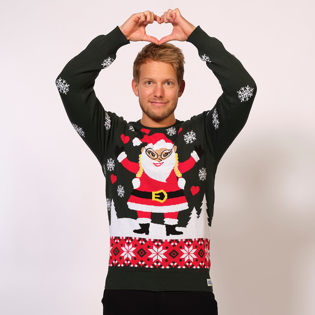 En mand viser et hjertehåndtegn iført en fint julesweater med en nisse.