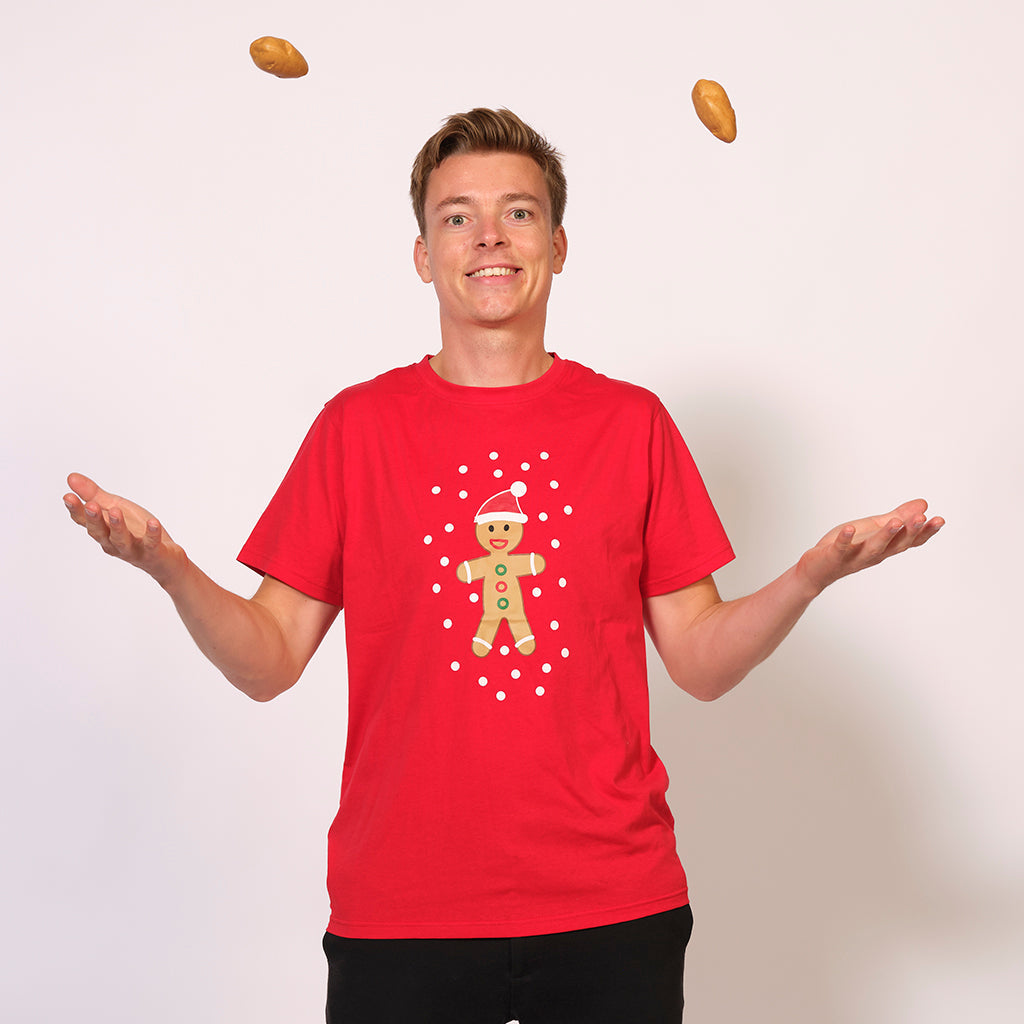 En mand poserer i en rød T-shirt, hvor der er en kagemand på.