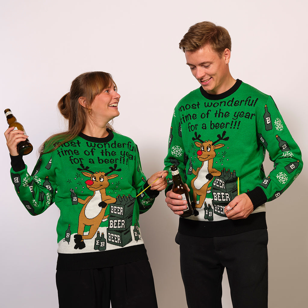 En kvinde og en mand iført en grøn julesweater med øl i hænderne.