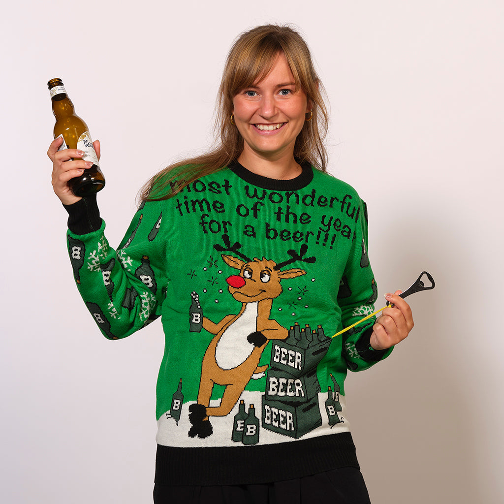 En kvinde, der holder en øl i hånden, er iført en grøn julesweater med et rensdyr.