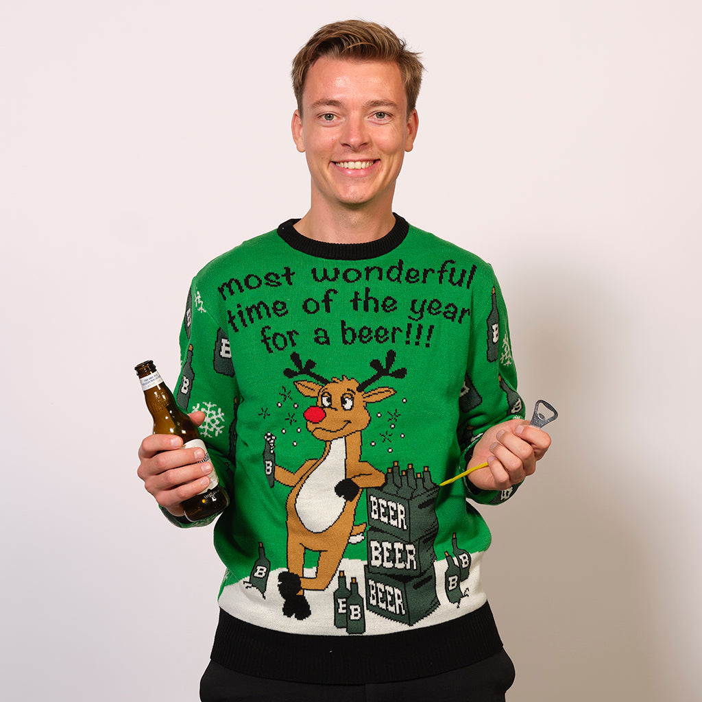 En mand med en øl i hånden er iført en grøn julesweater.