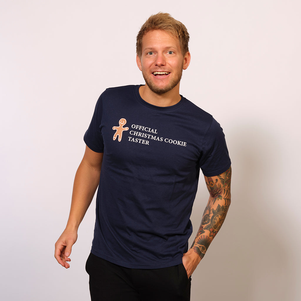 En mand er iført en blå T-shirt med en kagemand på.