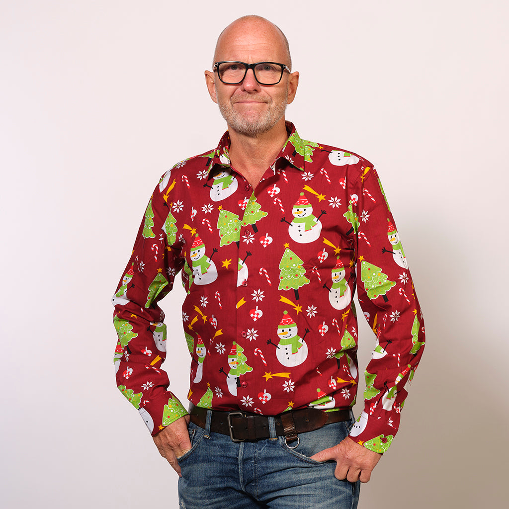 En mand med briller iført en rød juleskjorte.