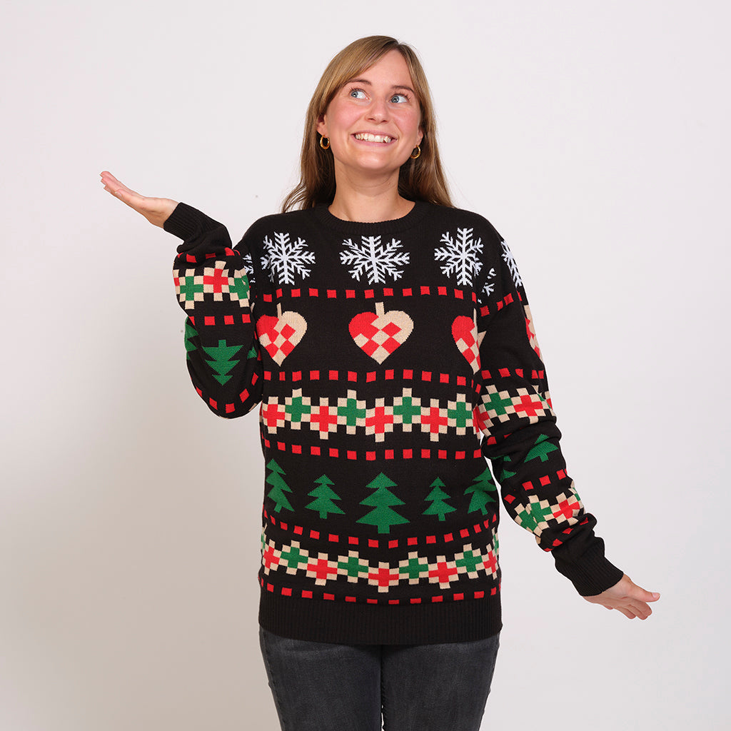 En smilende dame poserer i en sort julesweater.