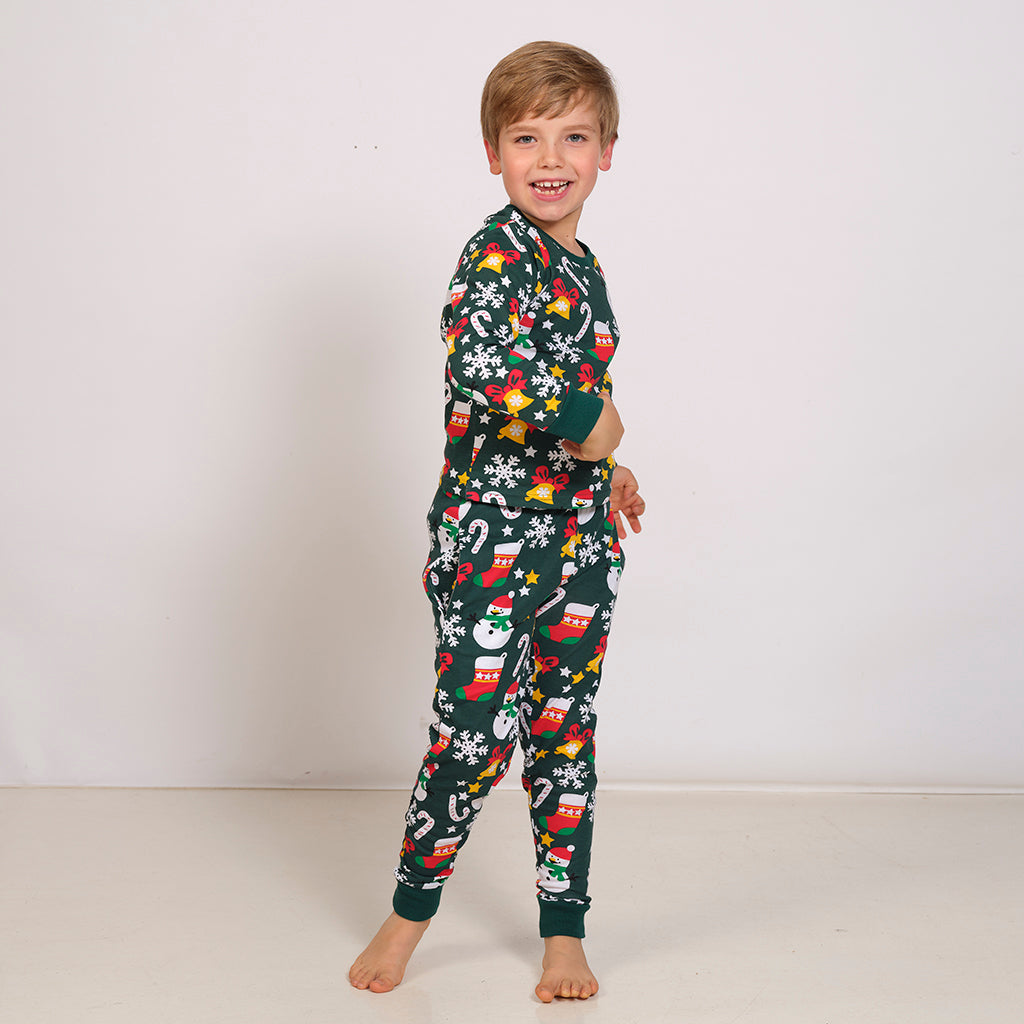 Et barn er iført en grøn julepyjamas.