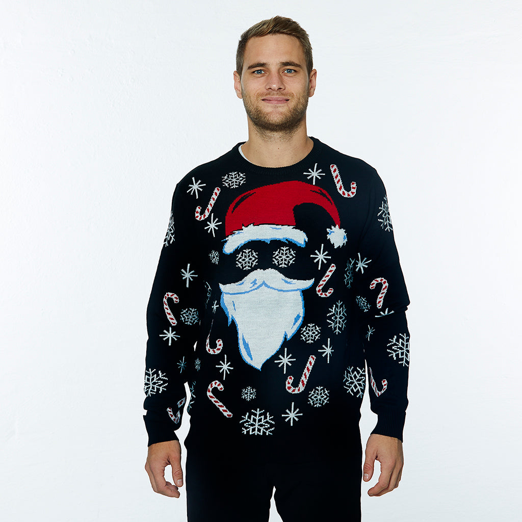 En smilende mand er iført en sort julesweater.