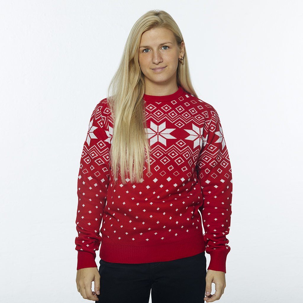 En kvinde iført en julesweater med snefnug.