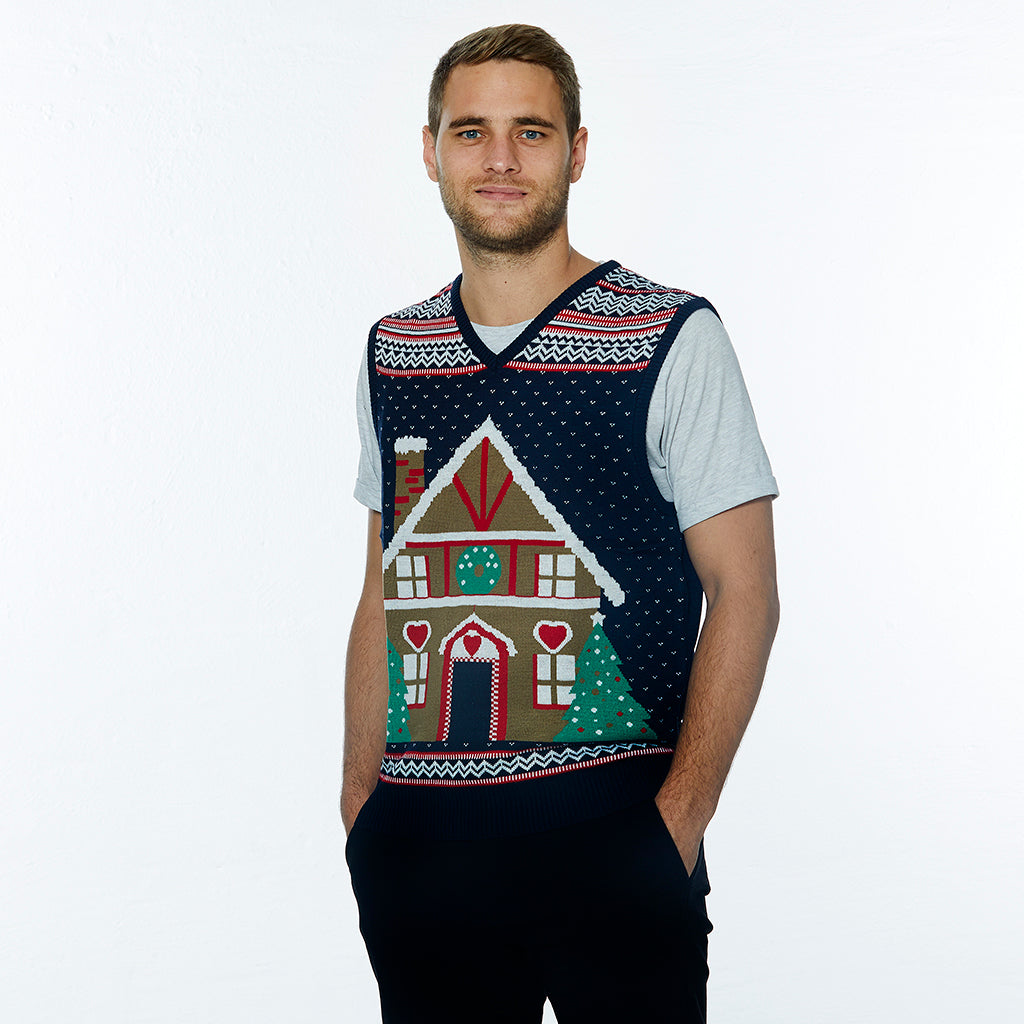 En mand iført en julevest med et kagehus på.