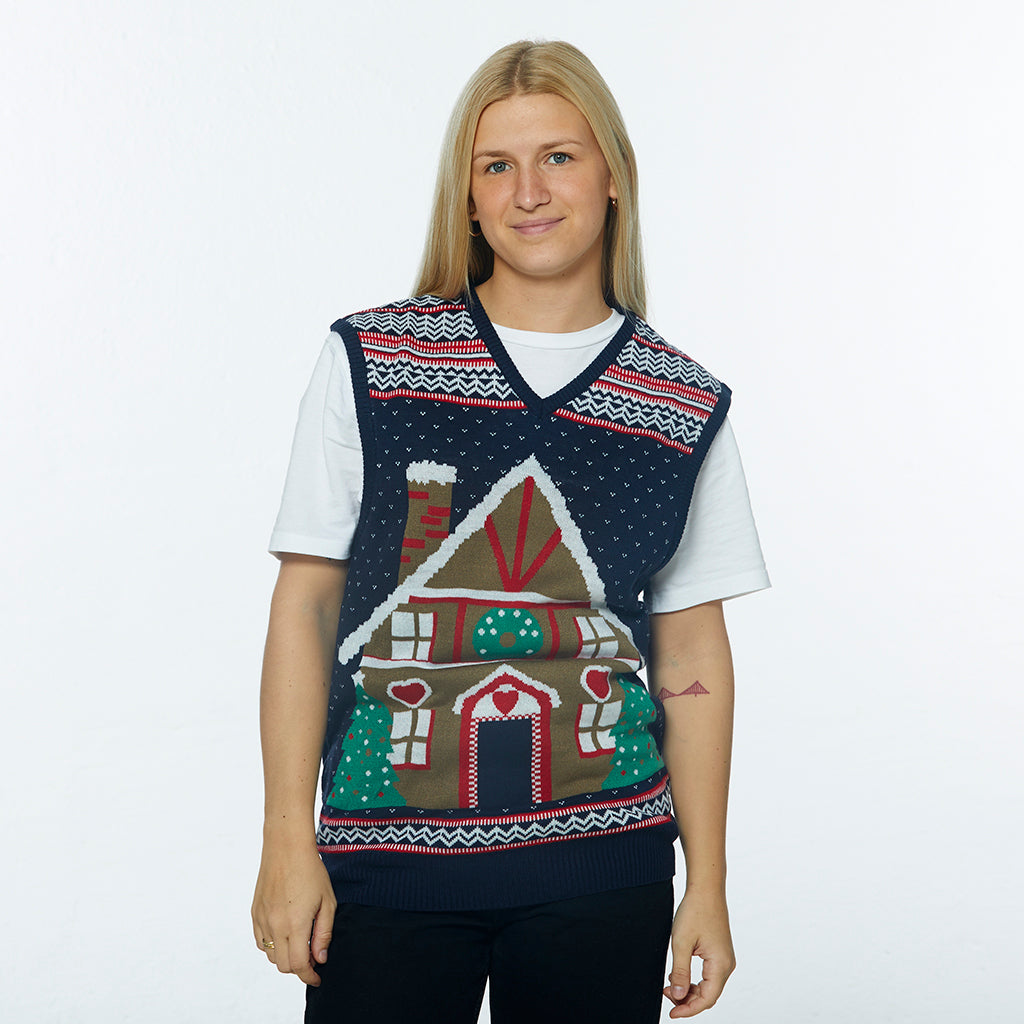 En dame iført en julevest med et kagehus og julemønster på.