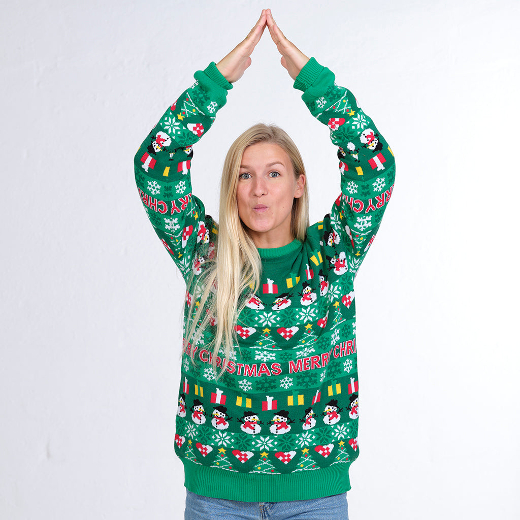 En kvinde poserer som et juletræer i en grøn julesweater.