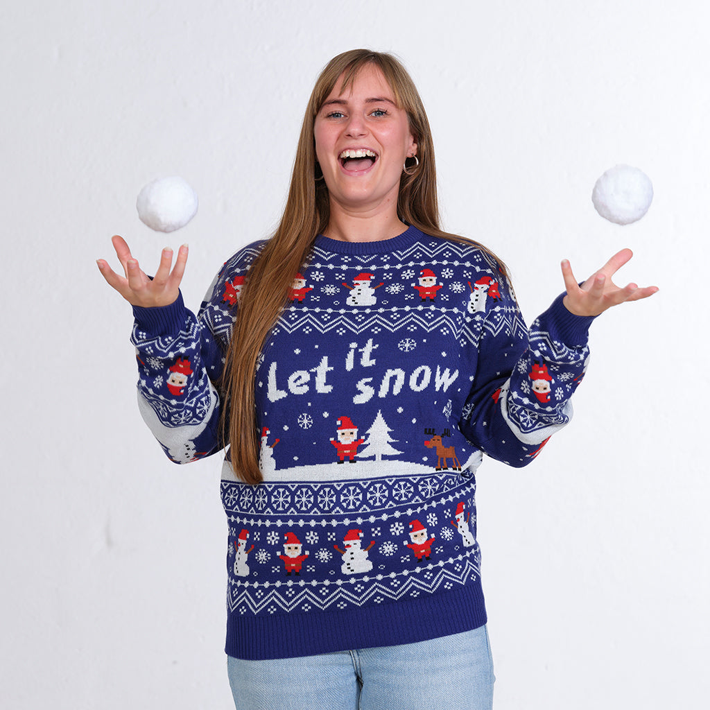 En kvinde kaster med snebolde og er iført en blå julesweater med et snelandskab.