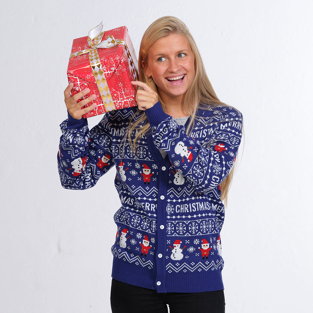En dame står med en gave i hænderne og er iført en blå julecardigan.