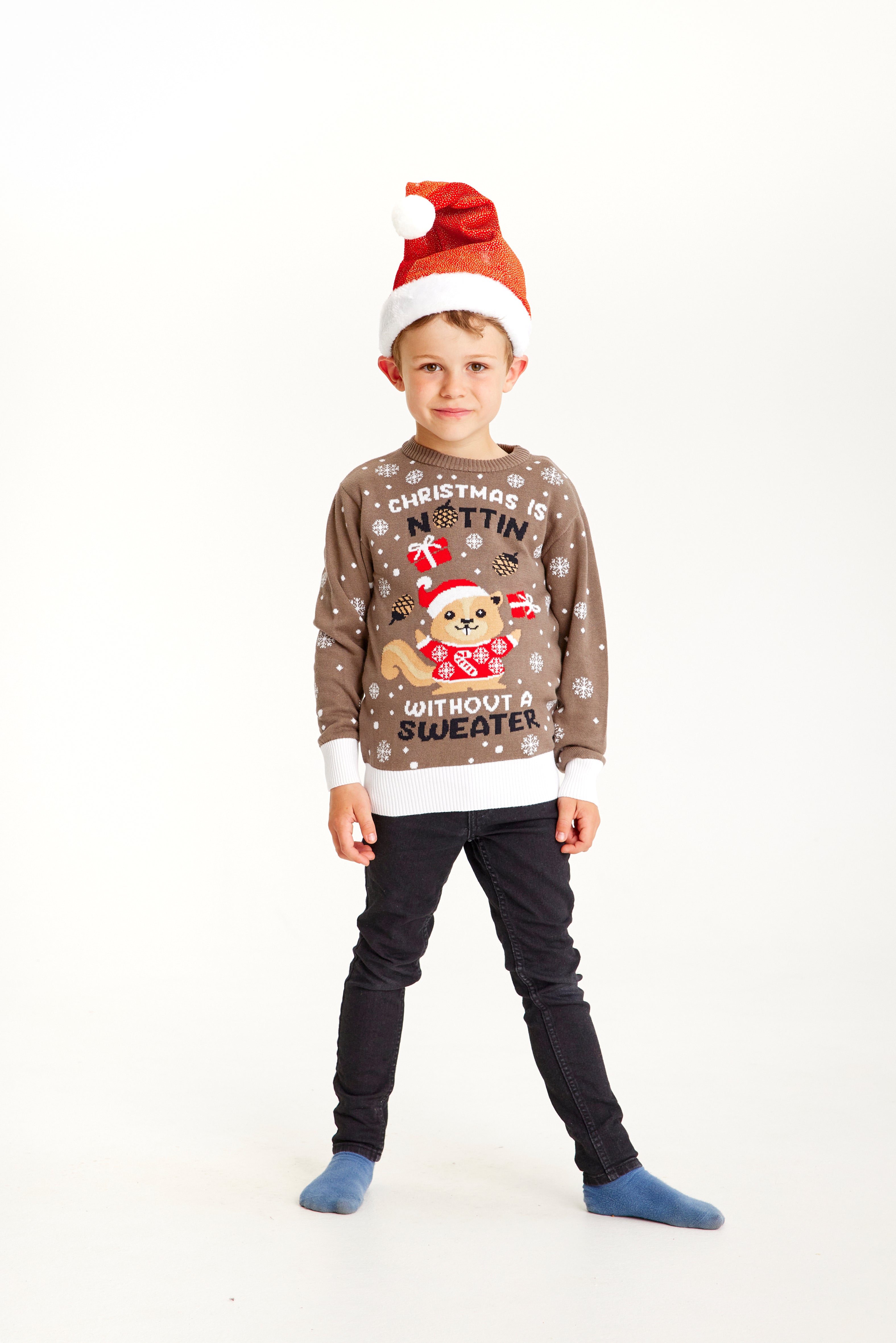 Et barn iført en nissehue og en brunlig julesweater med et egern.