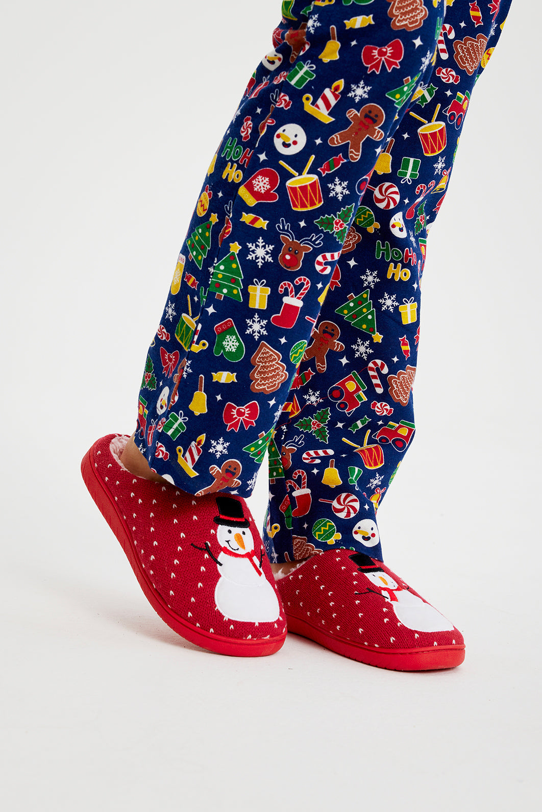 En par ben med røde juleslippers på.