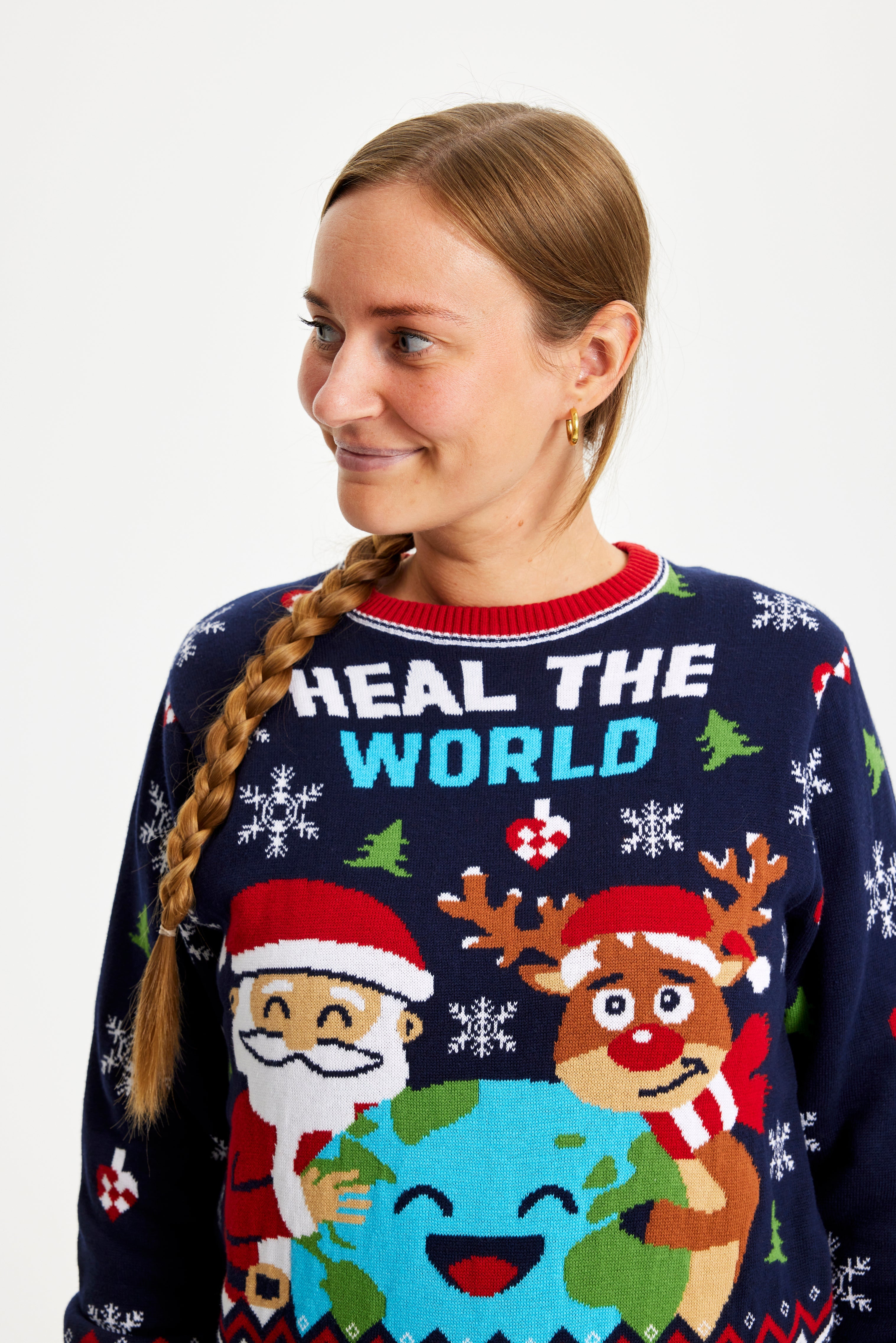 En smilende kvinde kigger til siden og er iført en julesweater.