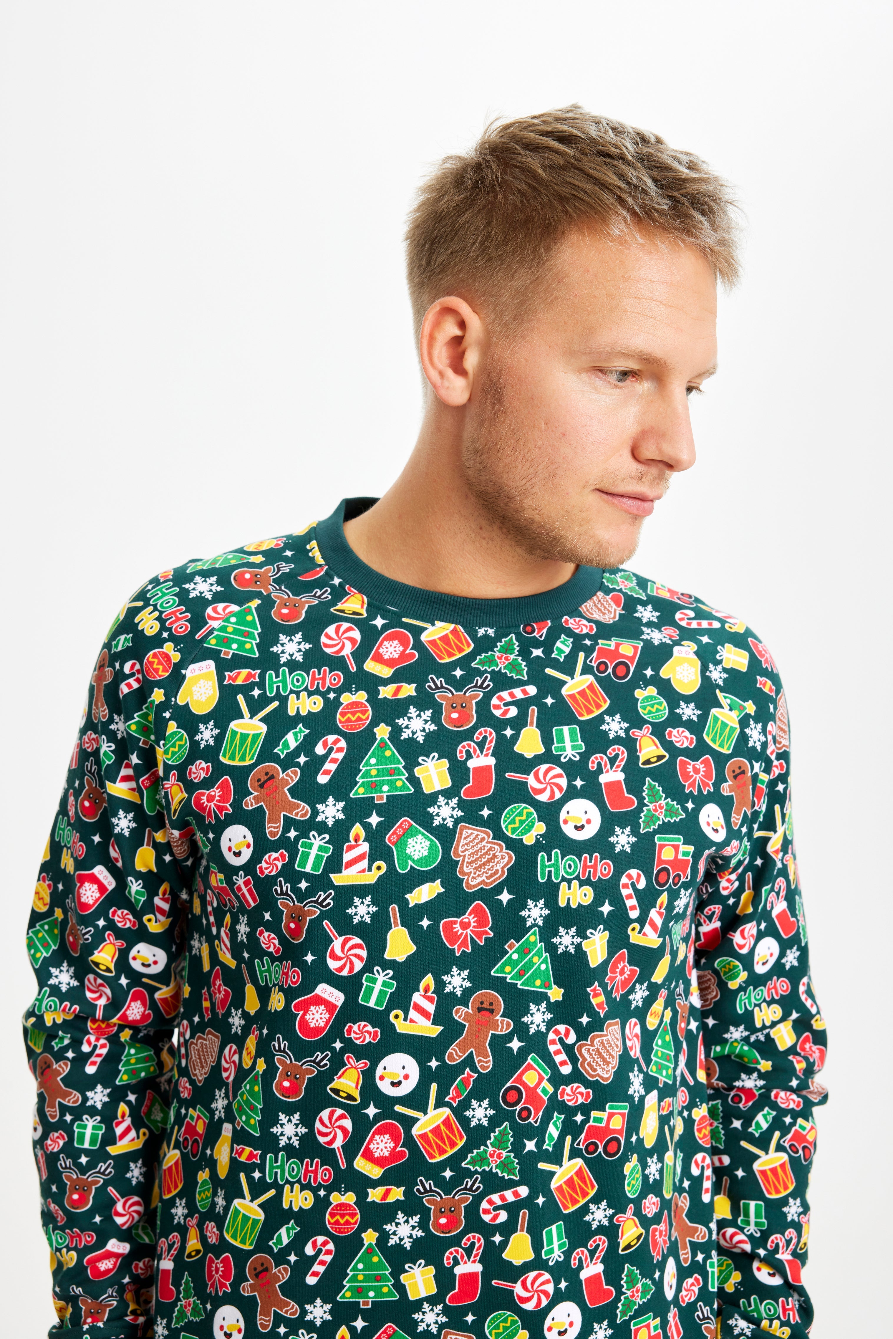 En mand kigger ned og er iført en julesweater med julesokker, kagemænd og juletræer.