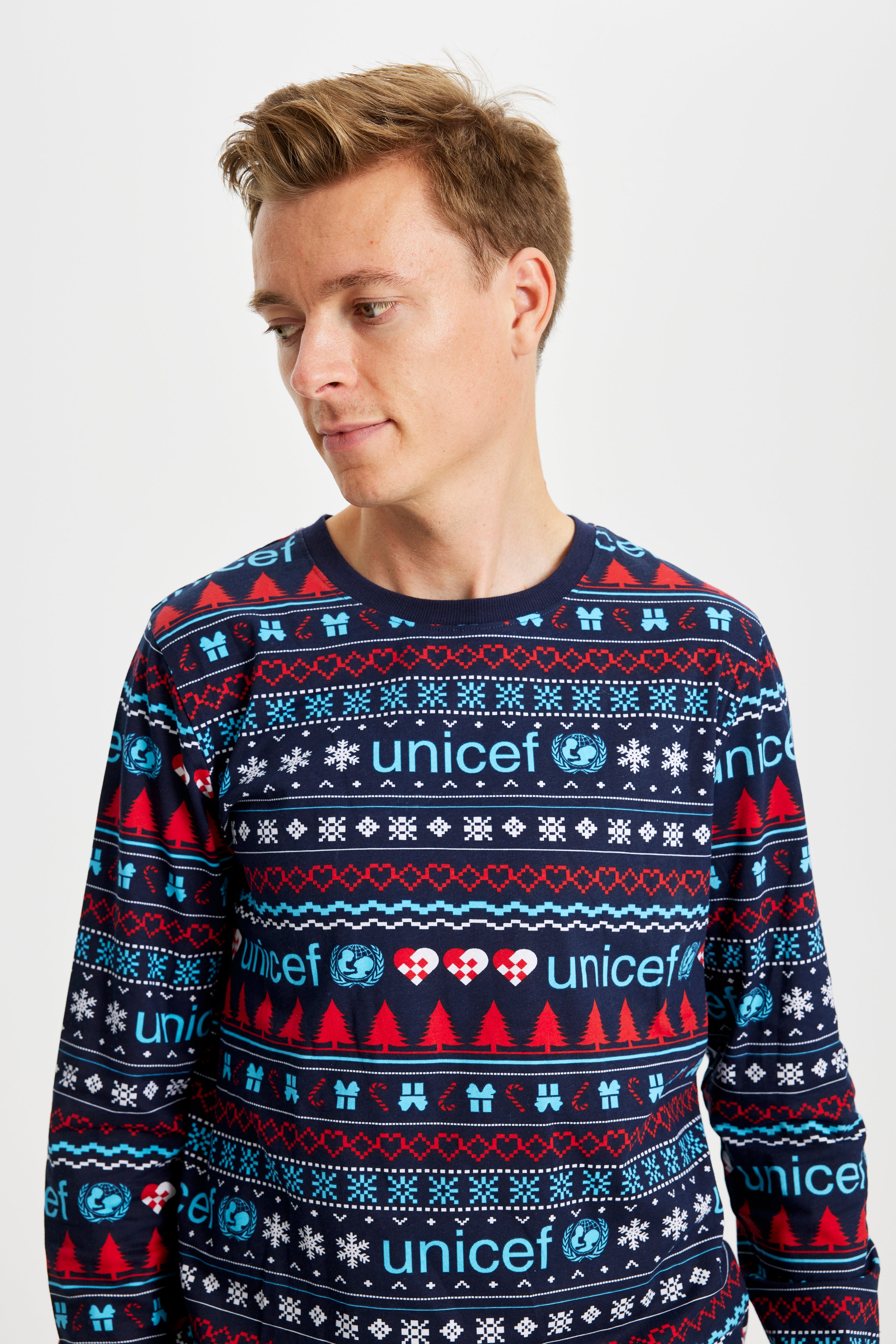 En mand iført en blå unicef julepyjamas.