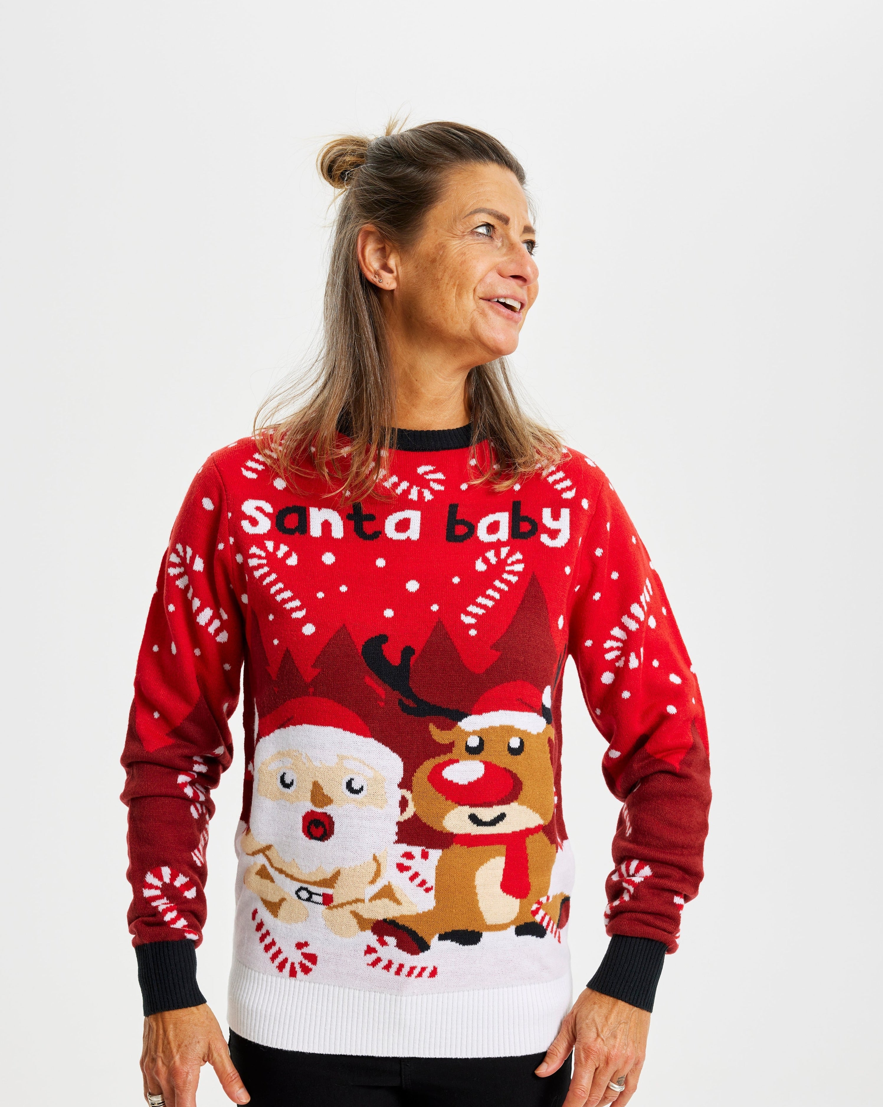 En glad dame iført en rød julesweater med citatet 