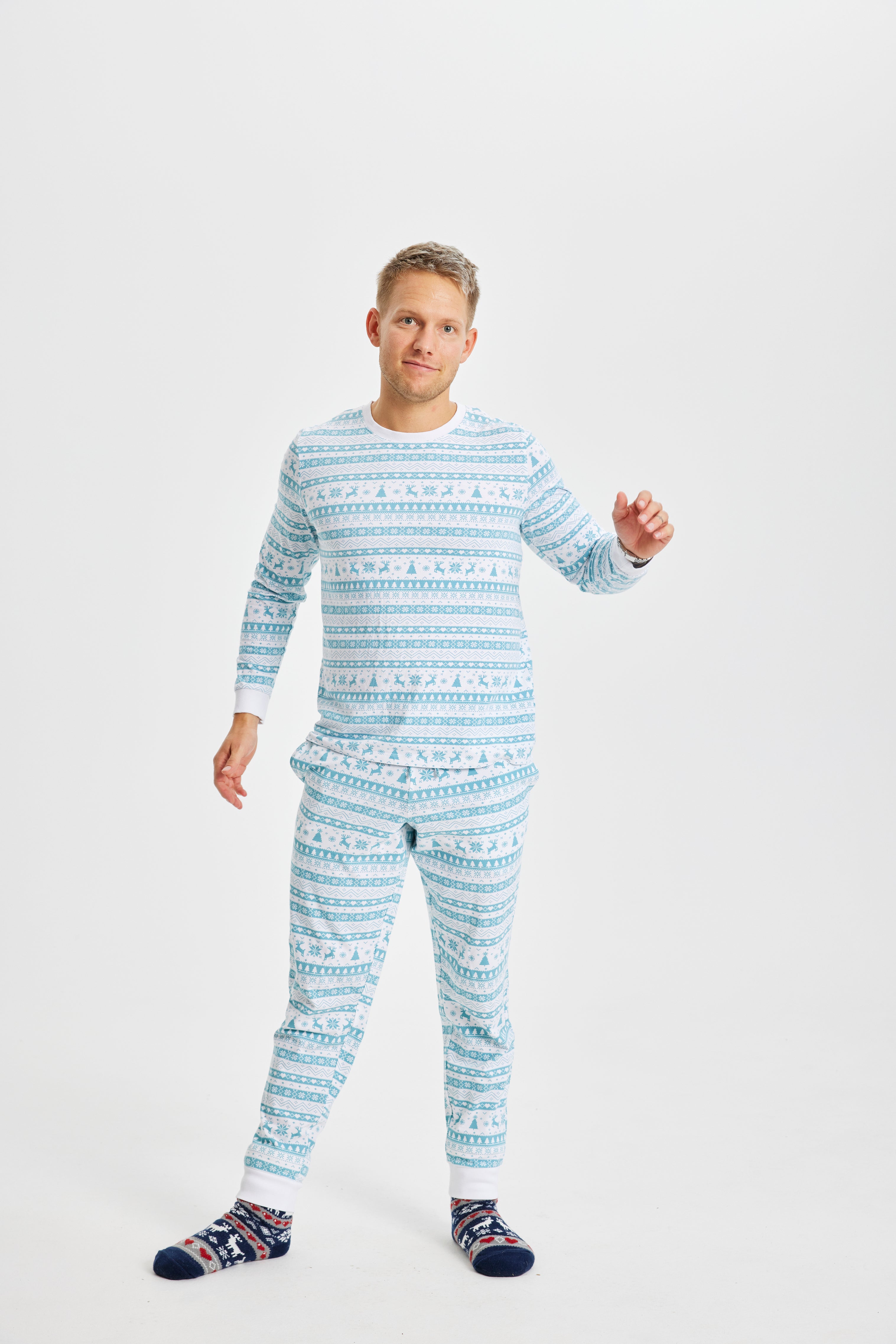 En mand iført julesokker og en blå og hvid, stribet pyjamas.