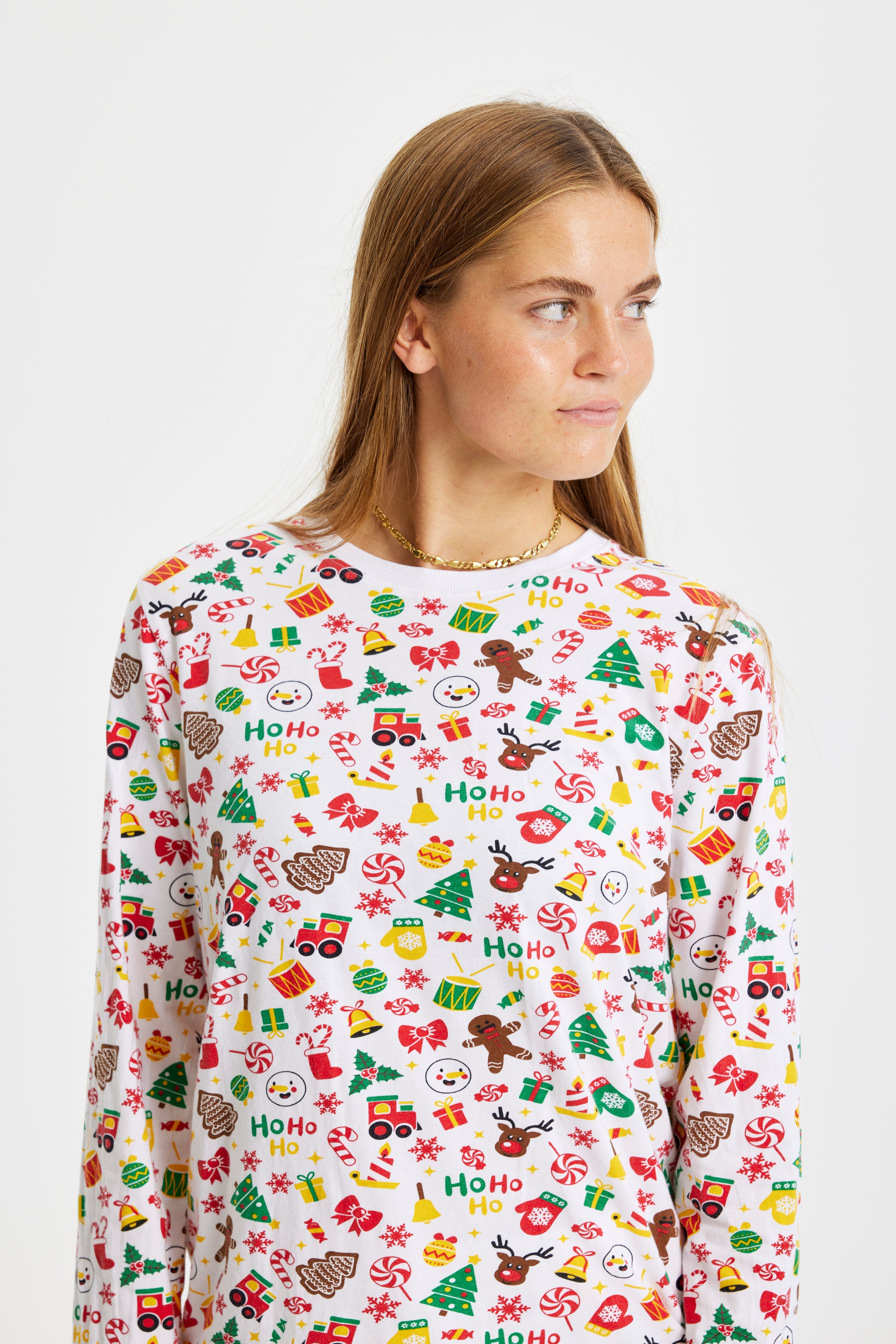 En dame poserer i en hvis julepyjamas med julemønster på.