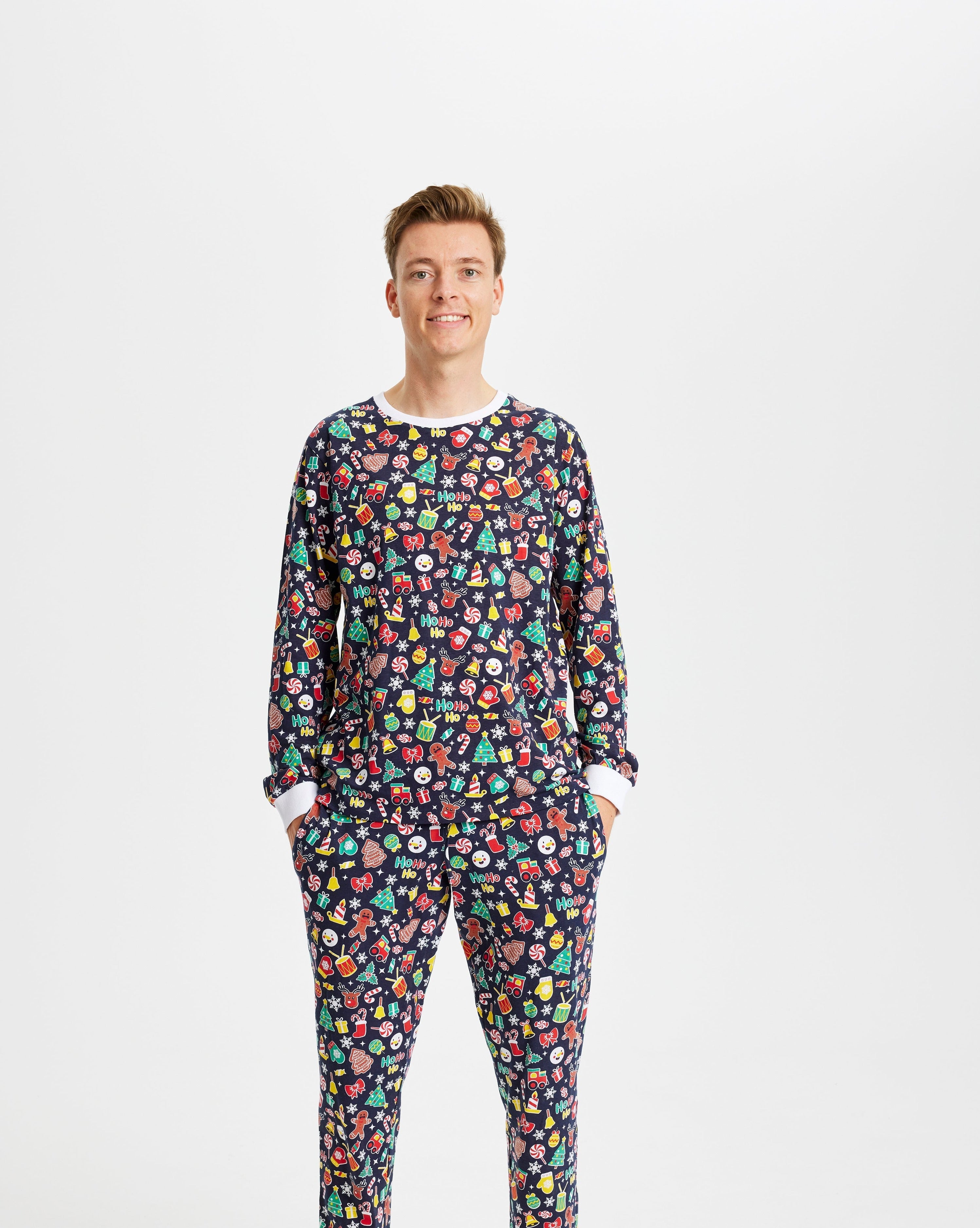 En smilende mand poserer i sin bjå julepyjamas med julemønster på.