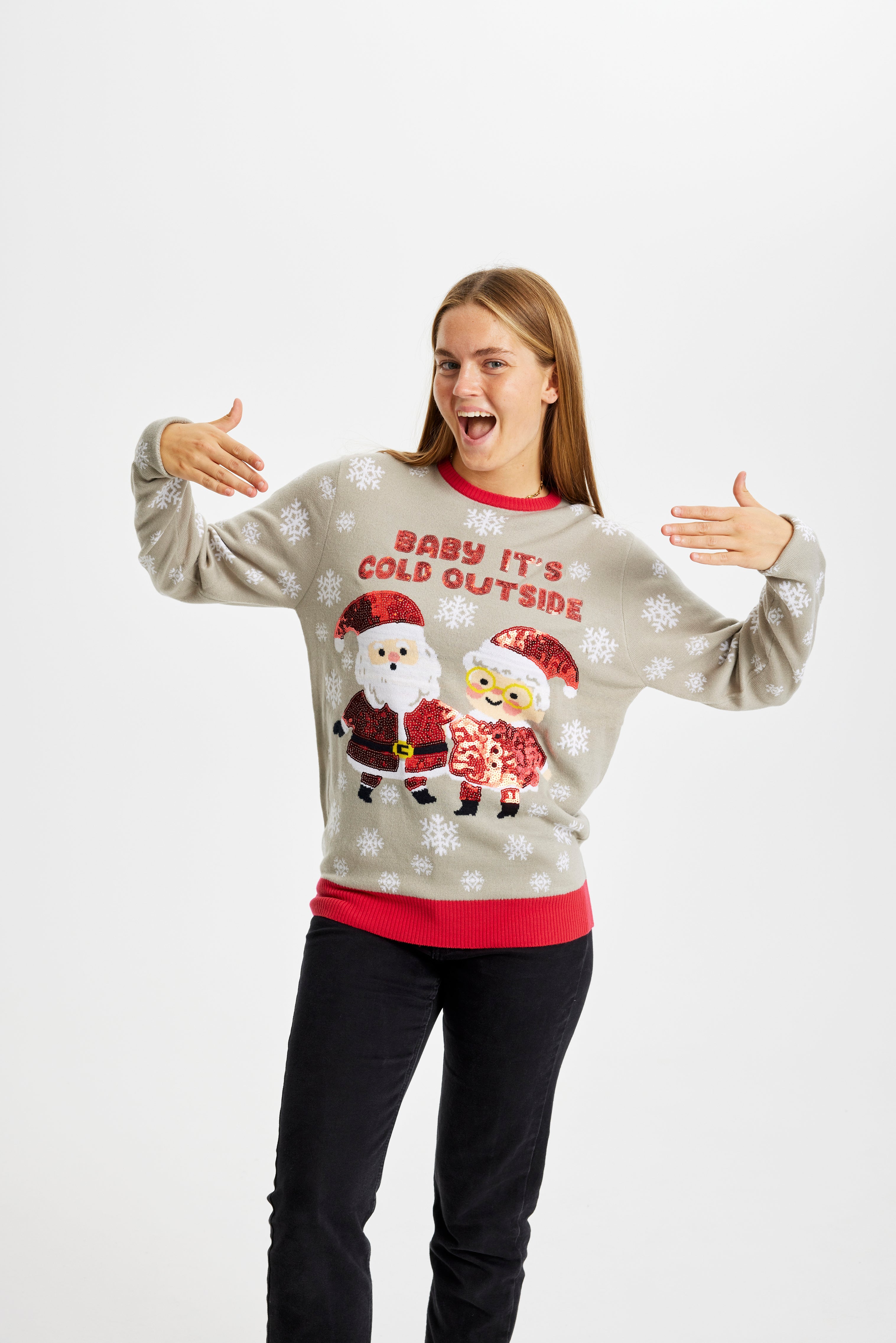 En glad dame poserer i en julesweater med citatet 