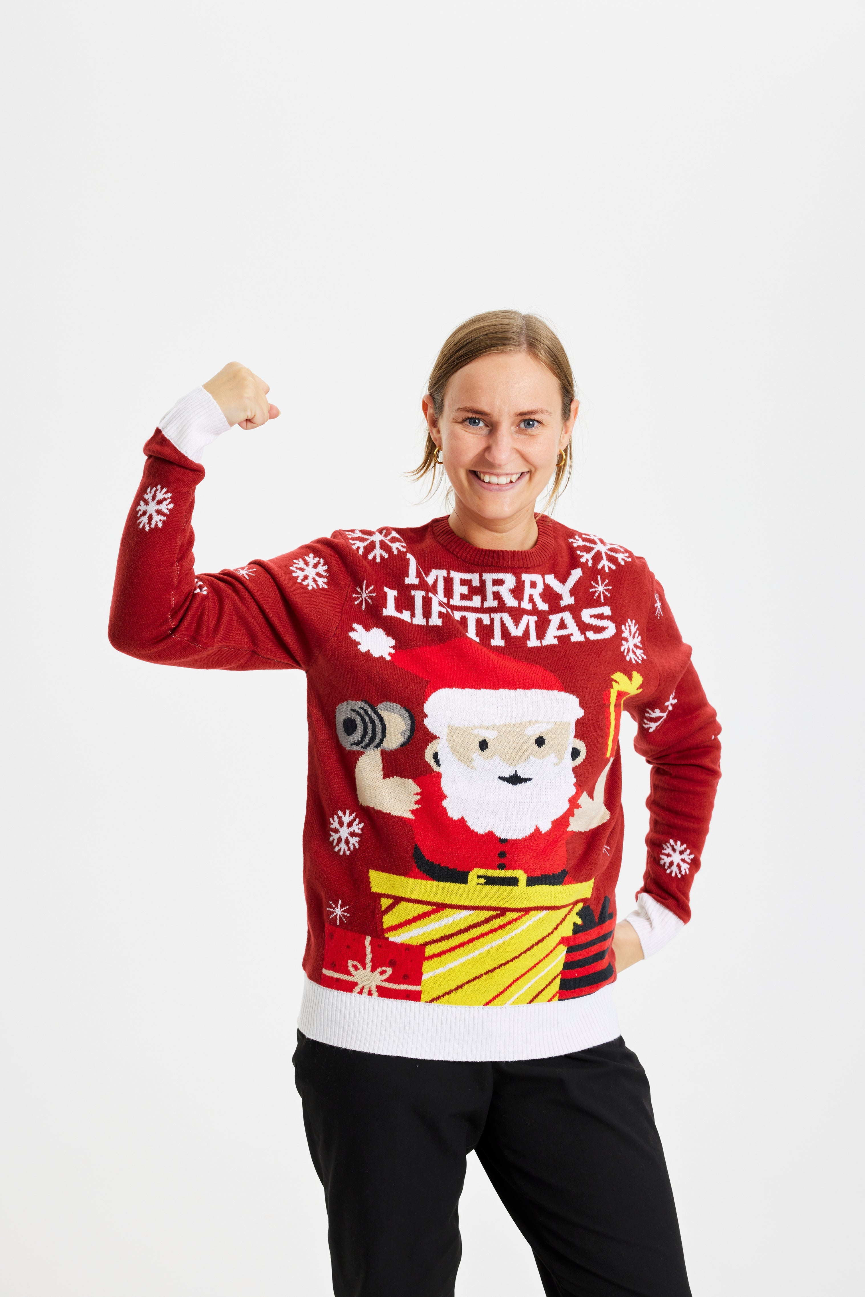 En kvinde i en rød julesweater med en julemand, der løfter en vægt.
