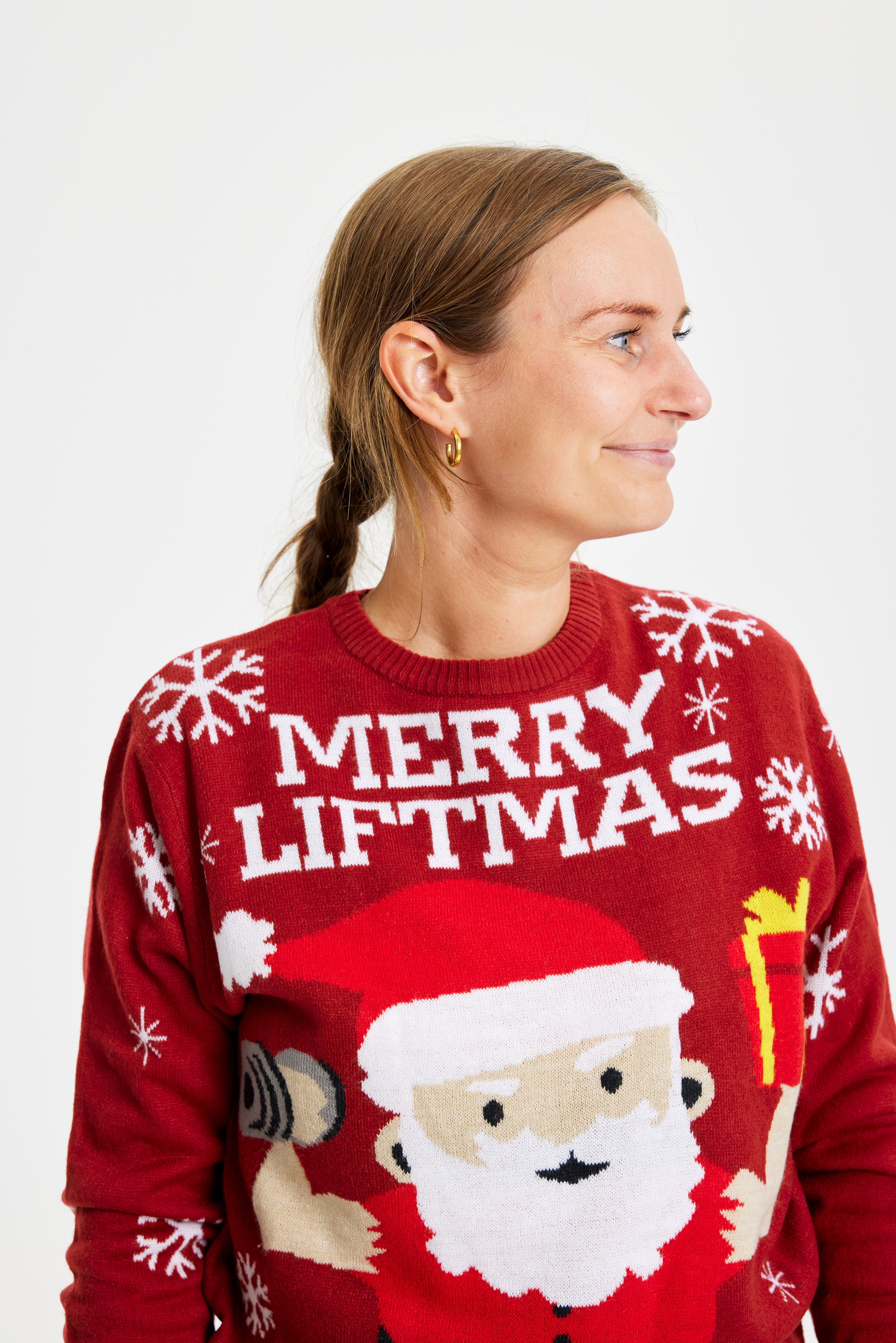 En smilende dame iført en rød julesweater.