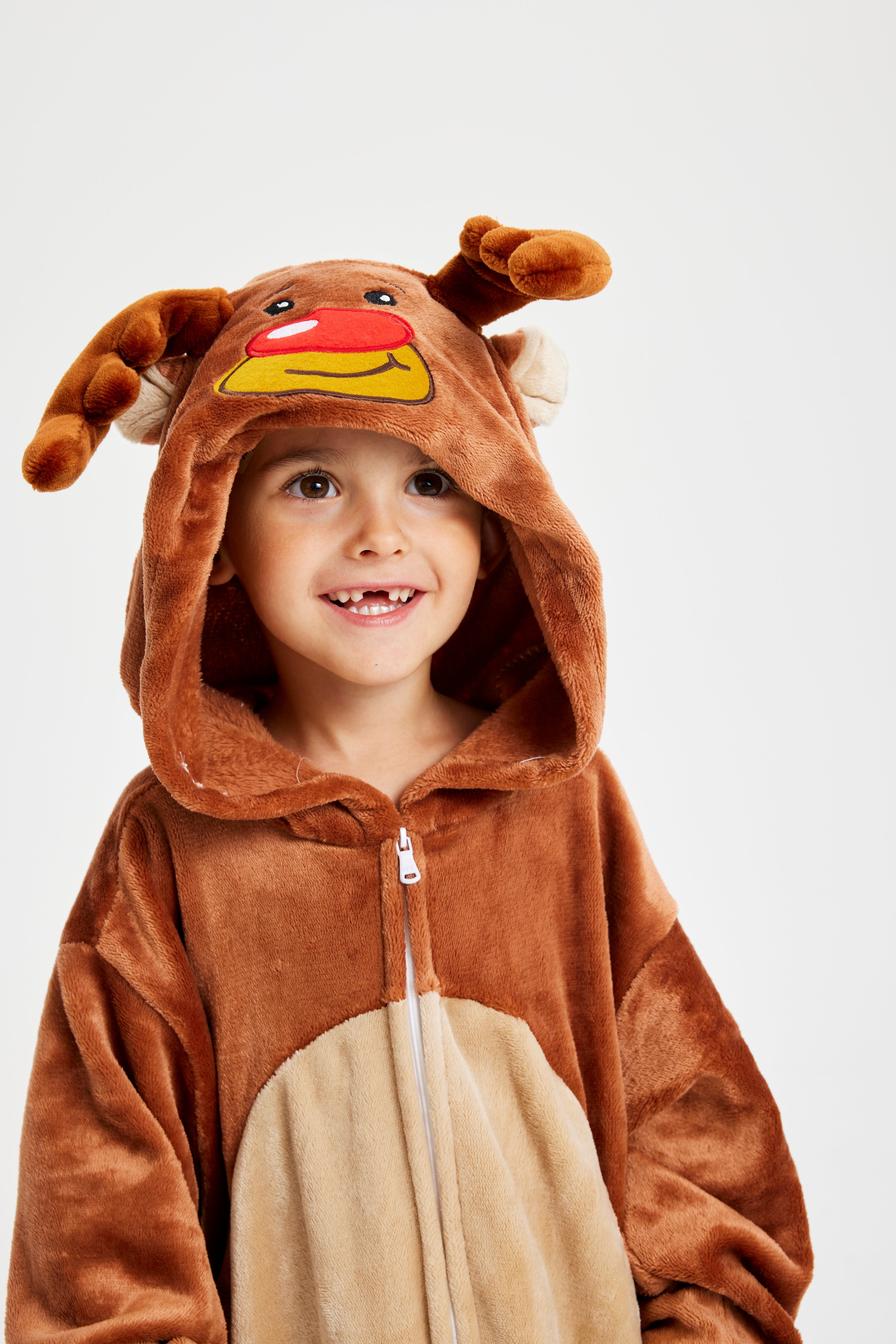 Et smilende barn iført en jumpsuit inspireret af rensdyret Rudolf.