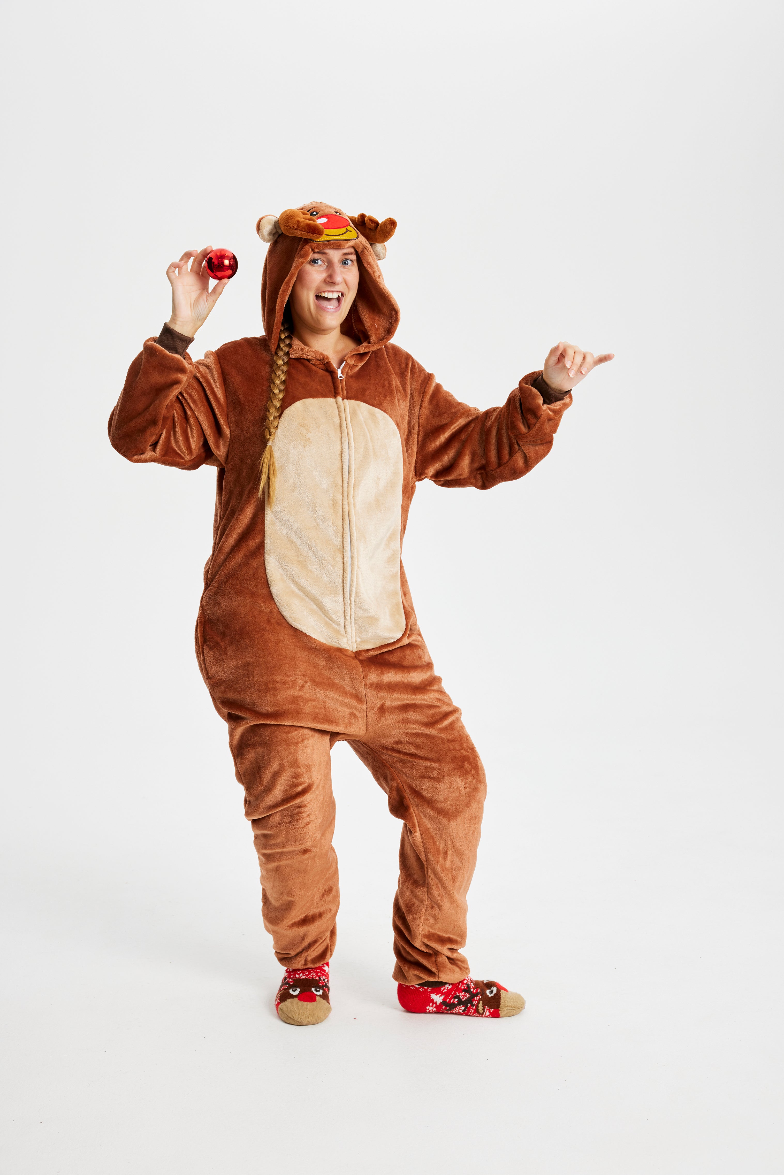 En damen med en rød julekugle er iført en Rudolf-inspireret jumpsuit.