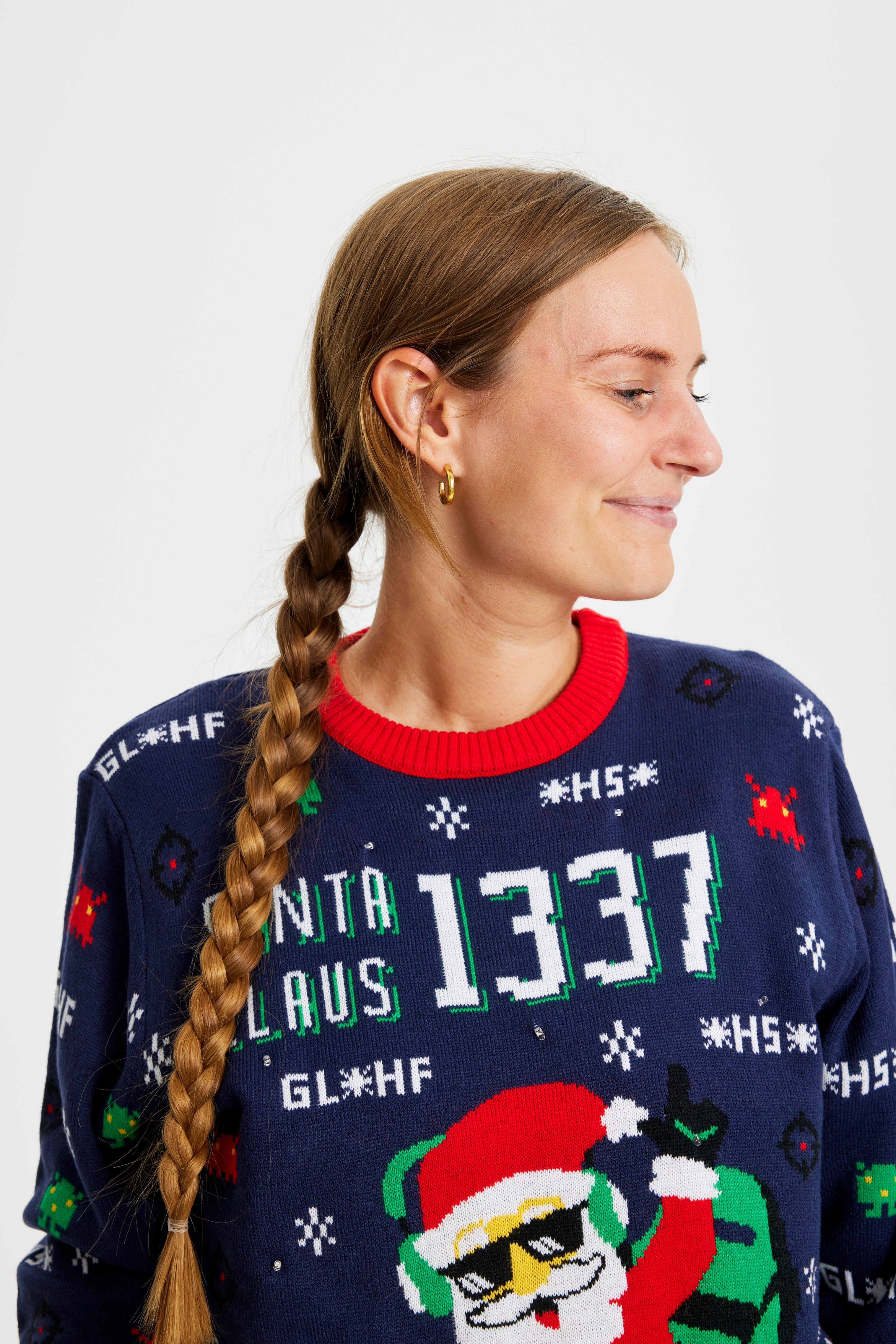 En smilende dame kigger til siden og er iført en julesweater.
