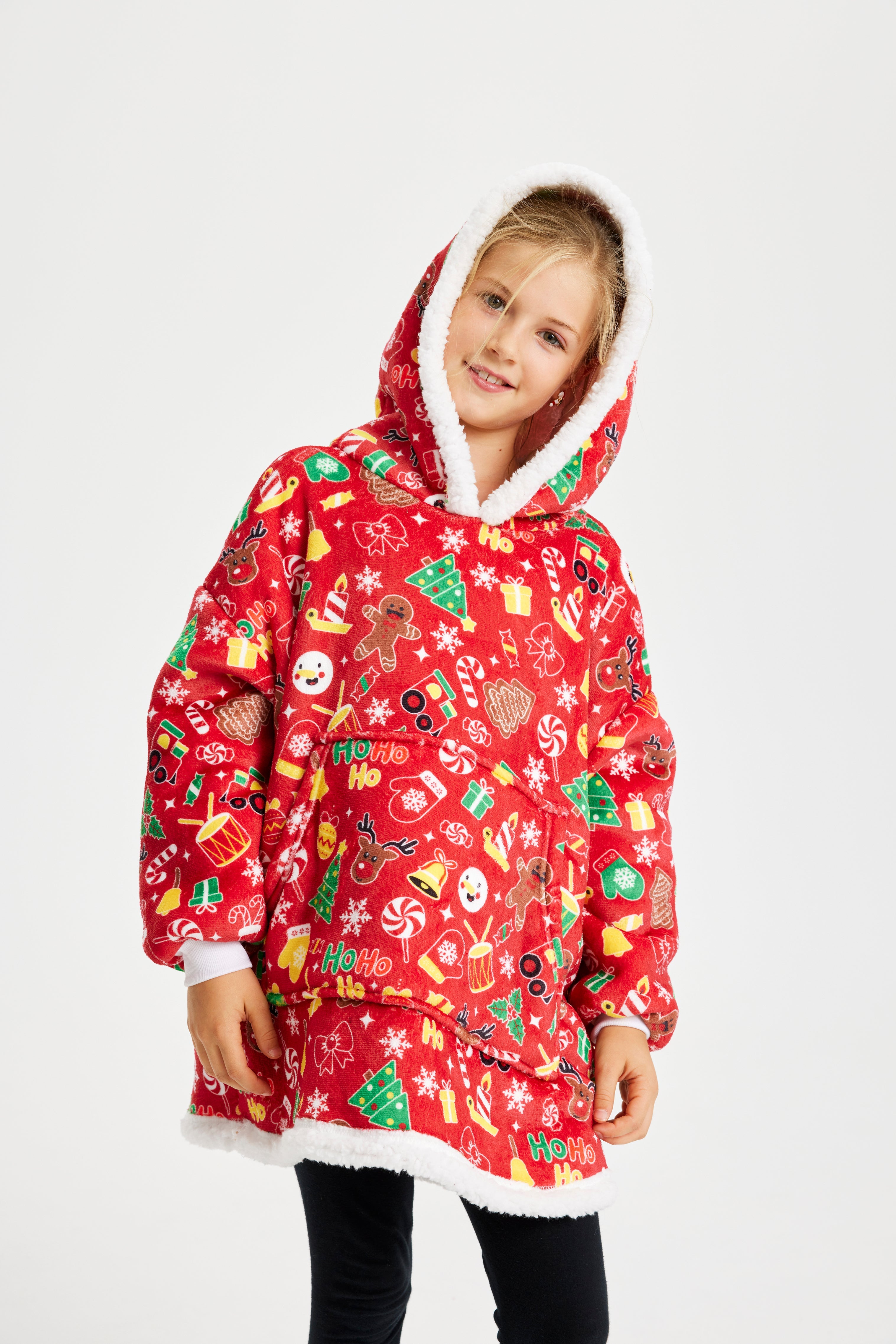 Et barn med hovedet på skrå iført en rød julehoodie, der går til knæene og har juleprint.