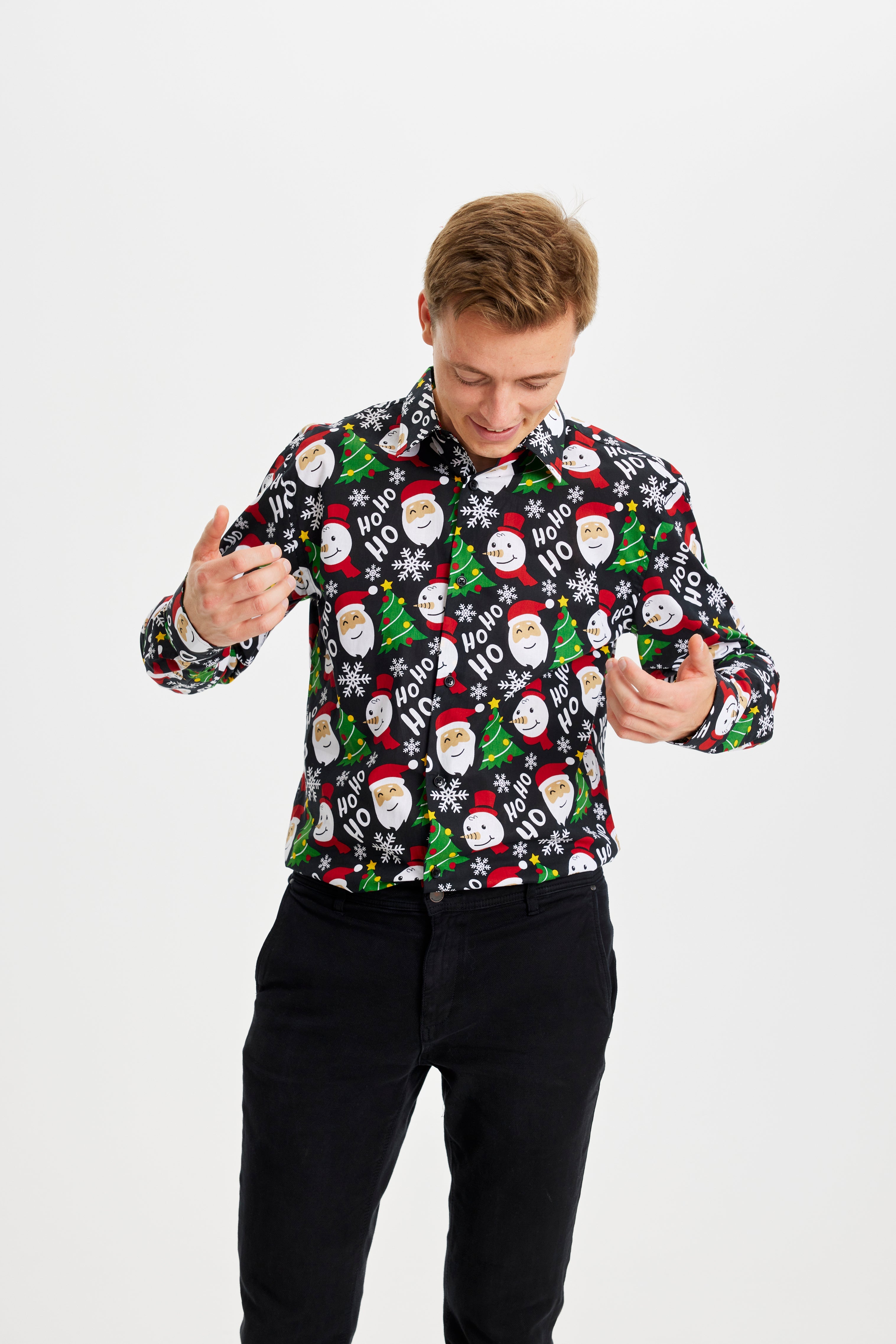 En mand kigger ned ad sig selv og er iført en juleskjorte.