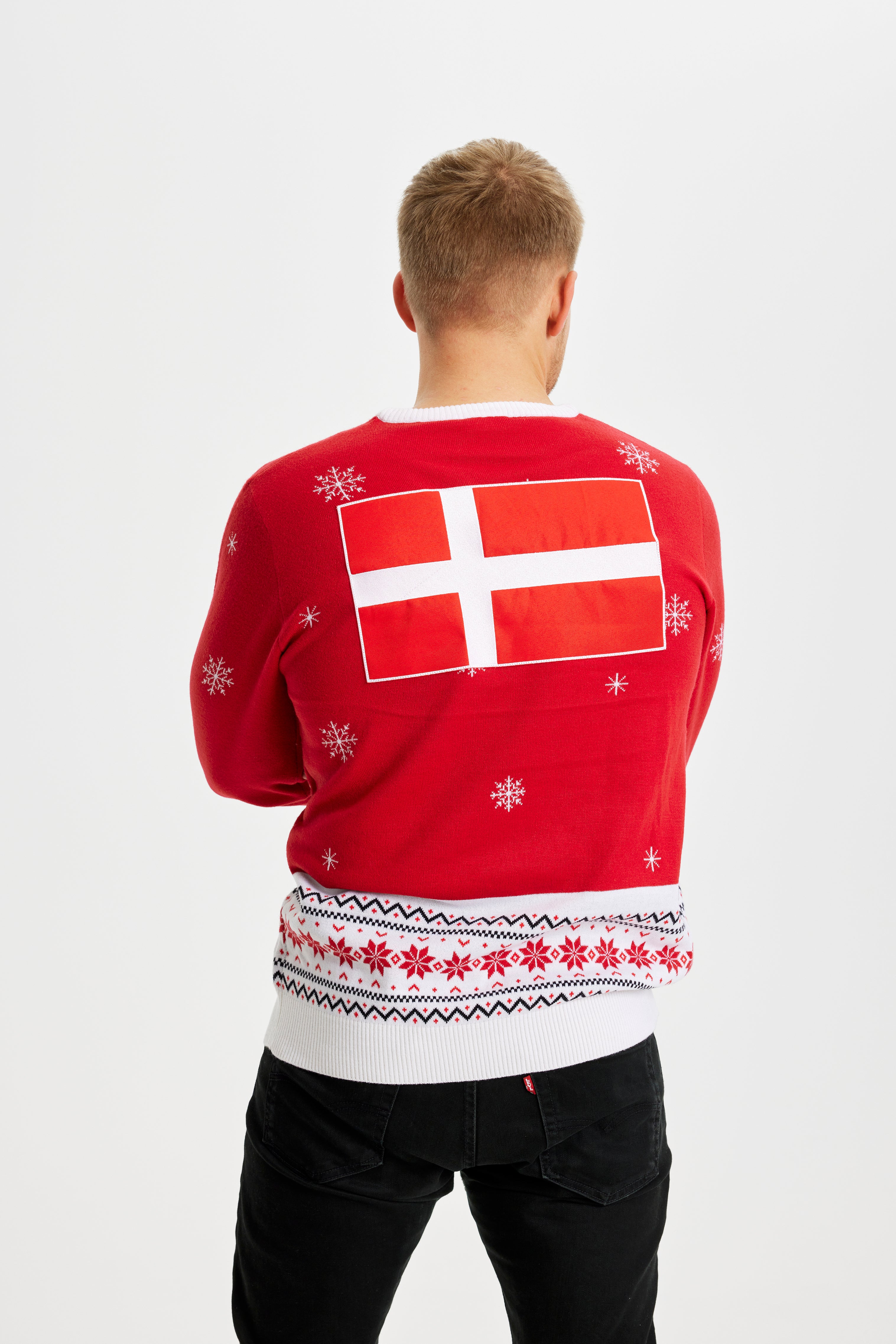 En mand iført en rød julesweater med Dannebrog.