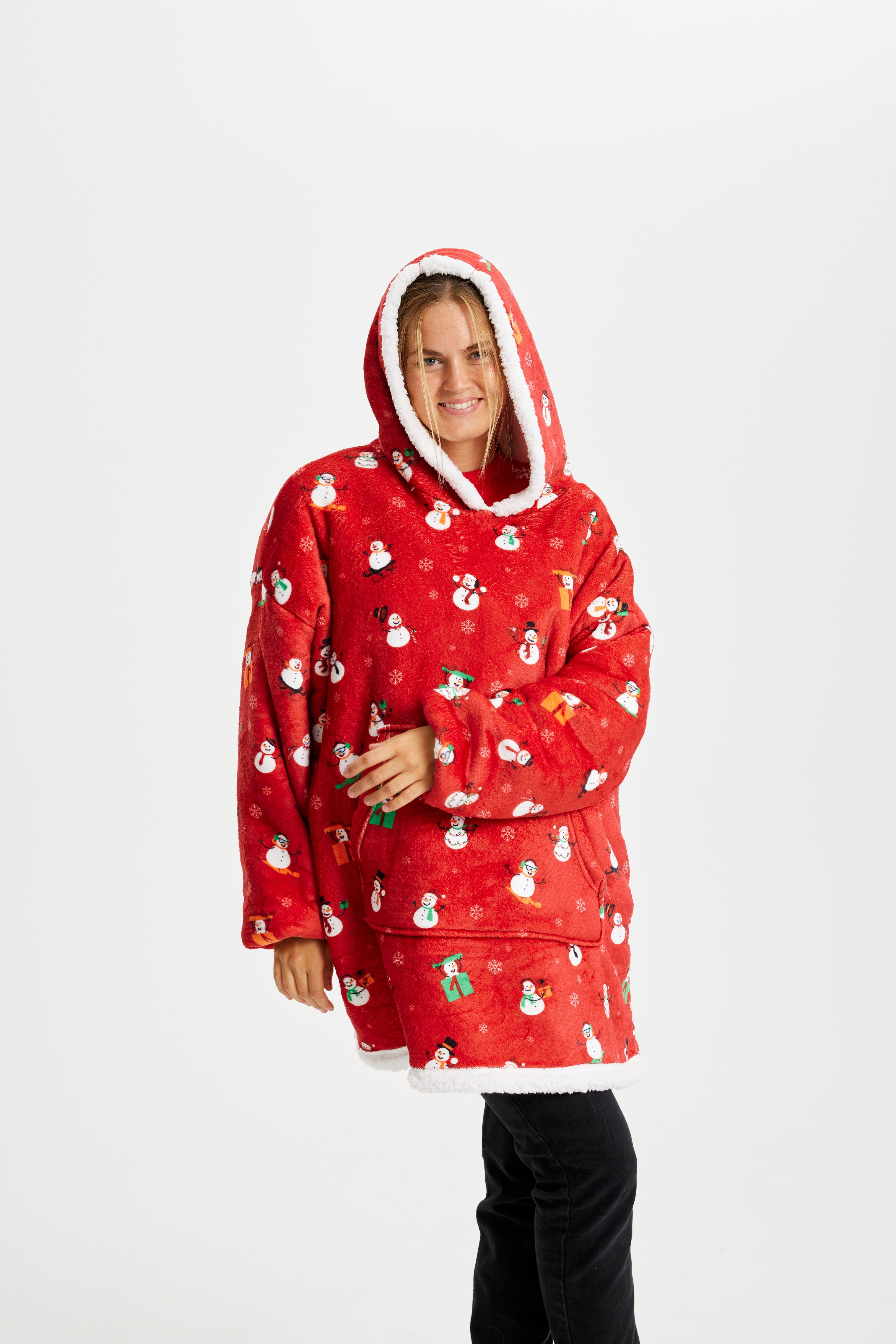 En sød kvinde iført en rød julehoodie poserer.