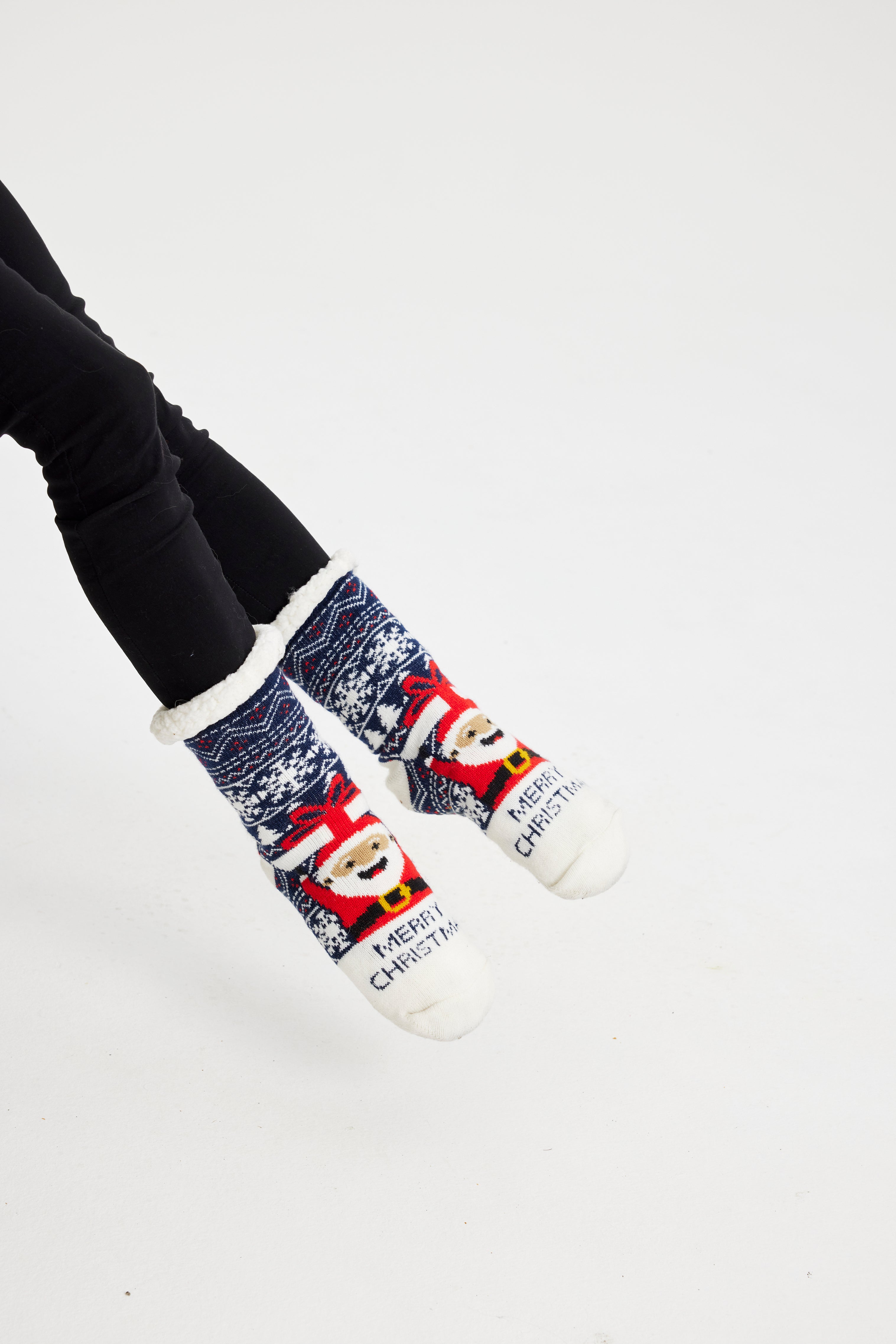 Et par julesokker med en smilende julemand og citatet 