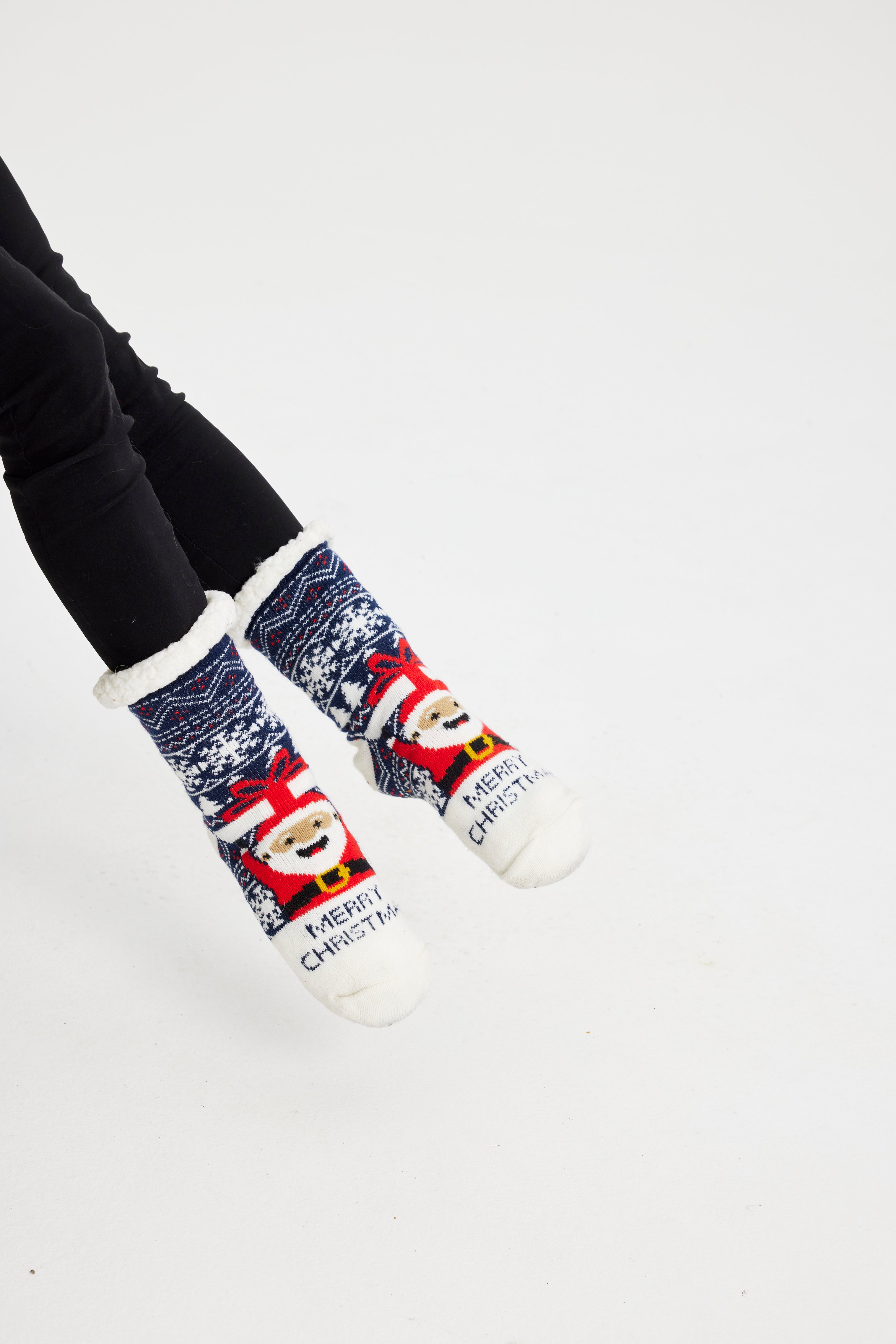 Et par blå, røde og hvide julesokker med en begejstret julemand med hænderne i vejret og snefnug.