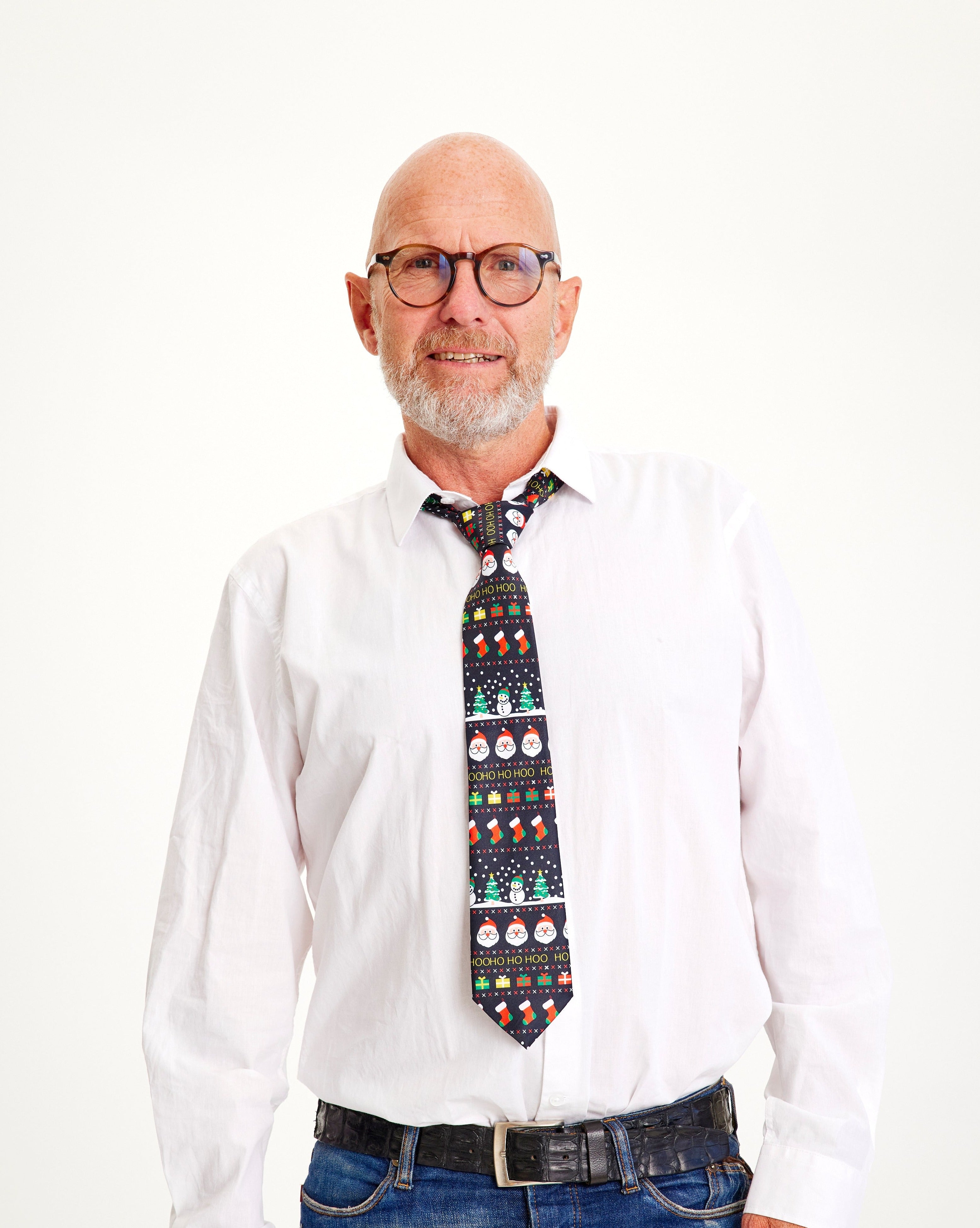 En herre iklædt en hvis skjorte og et mønstret juleslips.
